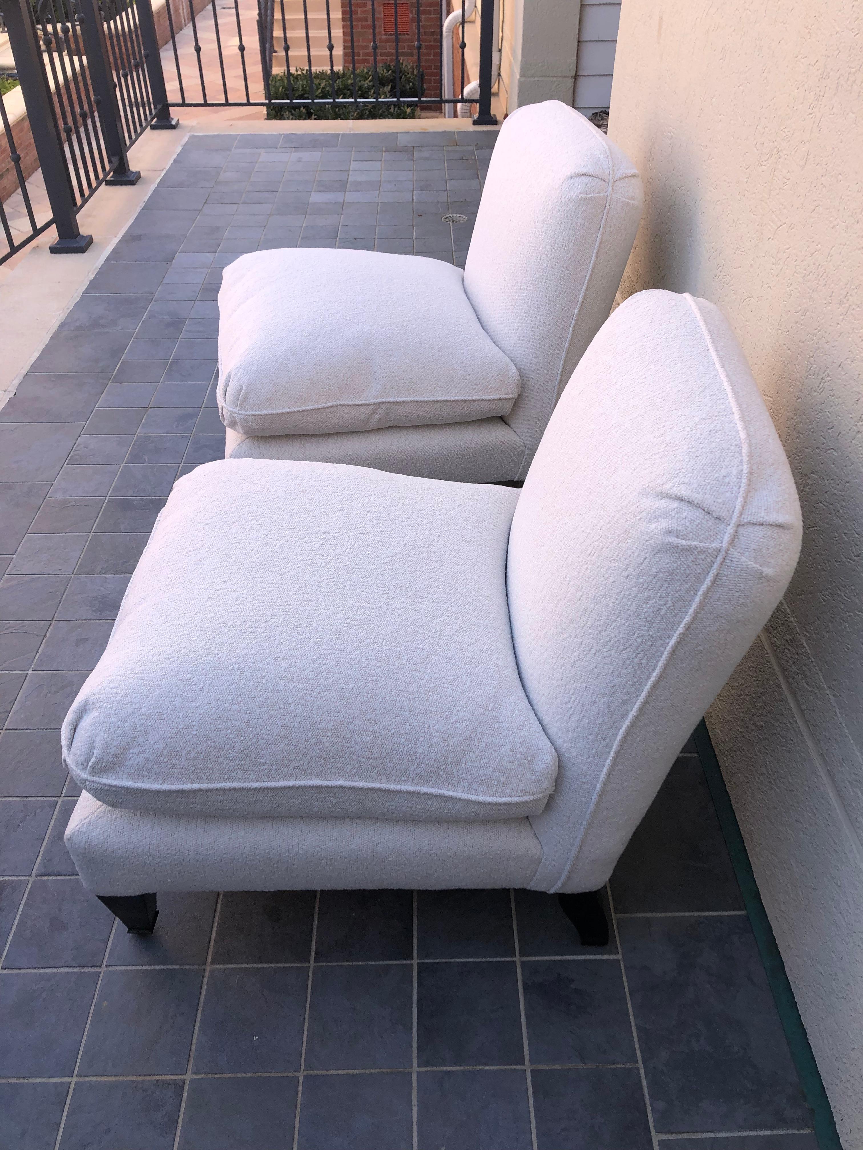 Striking pair of George Smith ottoman style slipper chairs newly upholstered in a neutral ivory boucle. Mahogany front legs and front brass casters. 
Seat cushions are down filled and polyester wrapped. 
Seat ht 20”
Seat depth 22.
 


