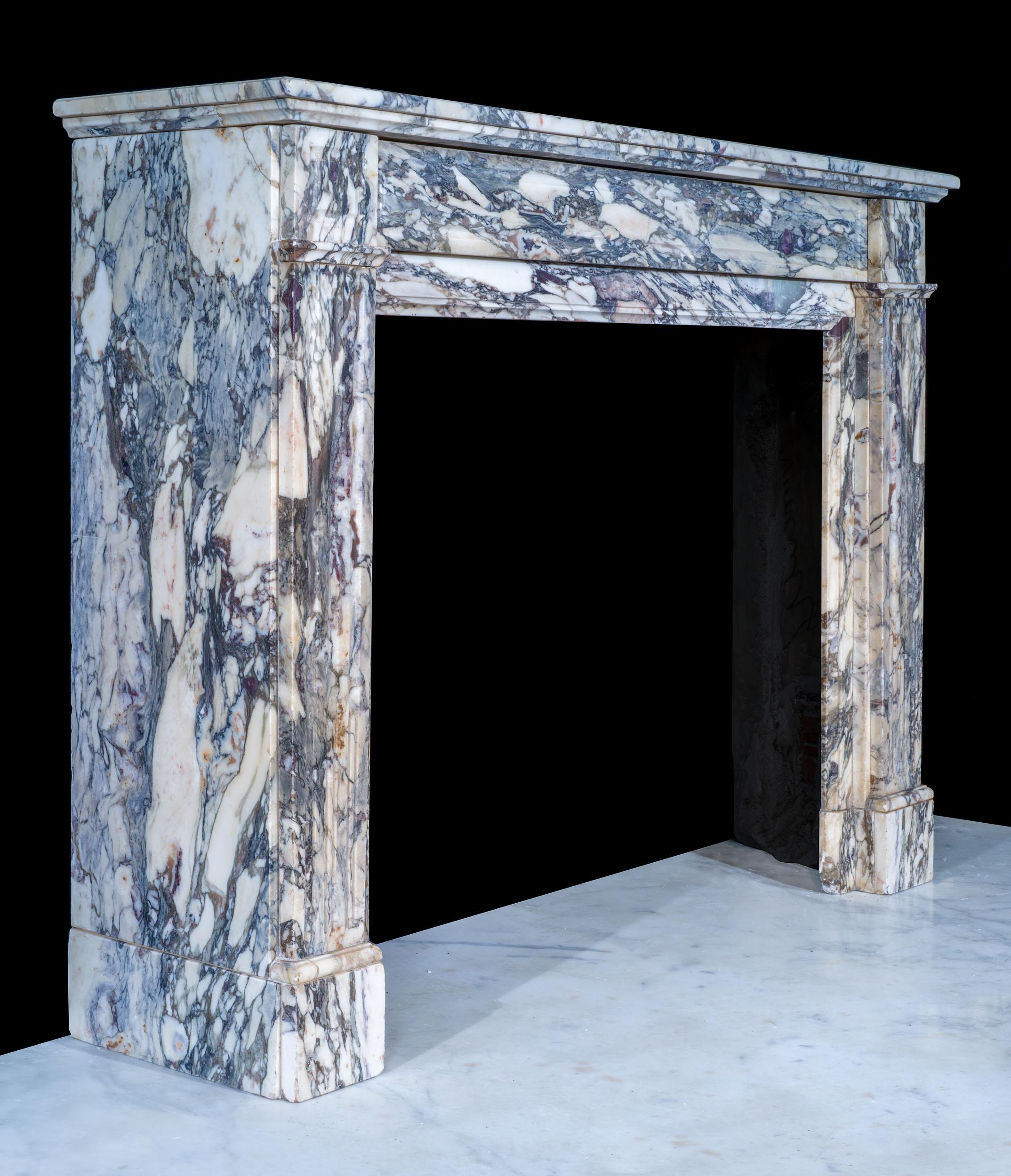 A Louis XVI fireplace in a boldly veined breche violette marble. The simply moulded shelf rests above a panelled frieze and square endblocks, over simple volute jambs. A celebration of this beautiful marble.

French, late 19th century.