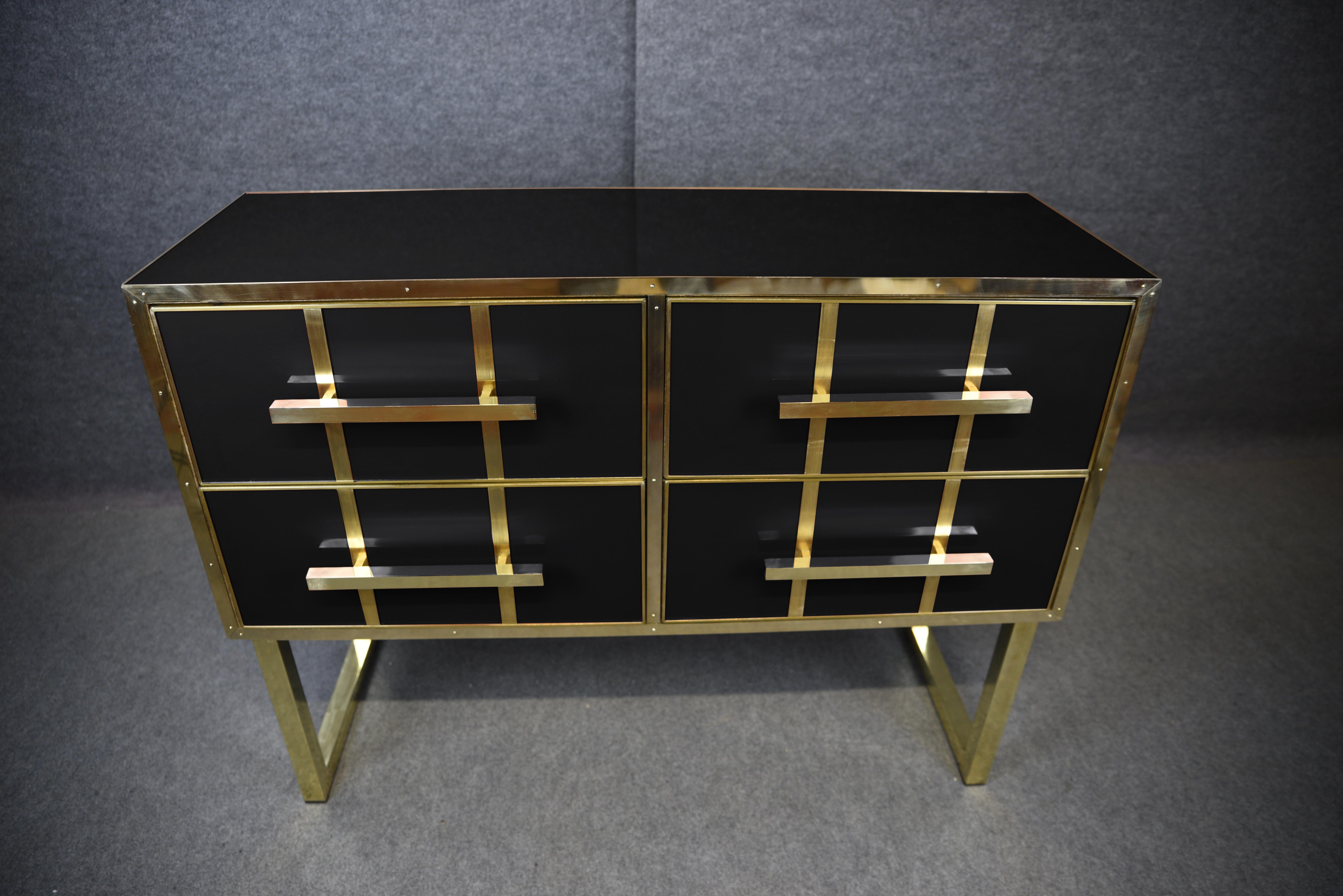 Esta impresionante cómoda italiana es una obra maestra del diseño moderno de mediados de siglo, elaborada con meticulosa atención al detalle. 

Fabricado en madera maciza, presenta bonitos detalles de cristal de Murano negro y herrajes de latón