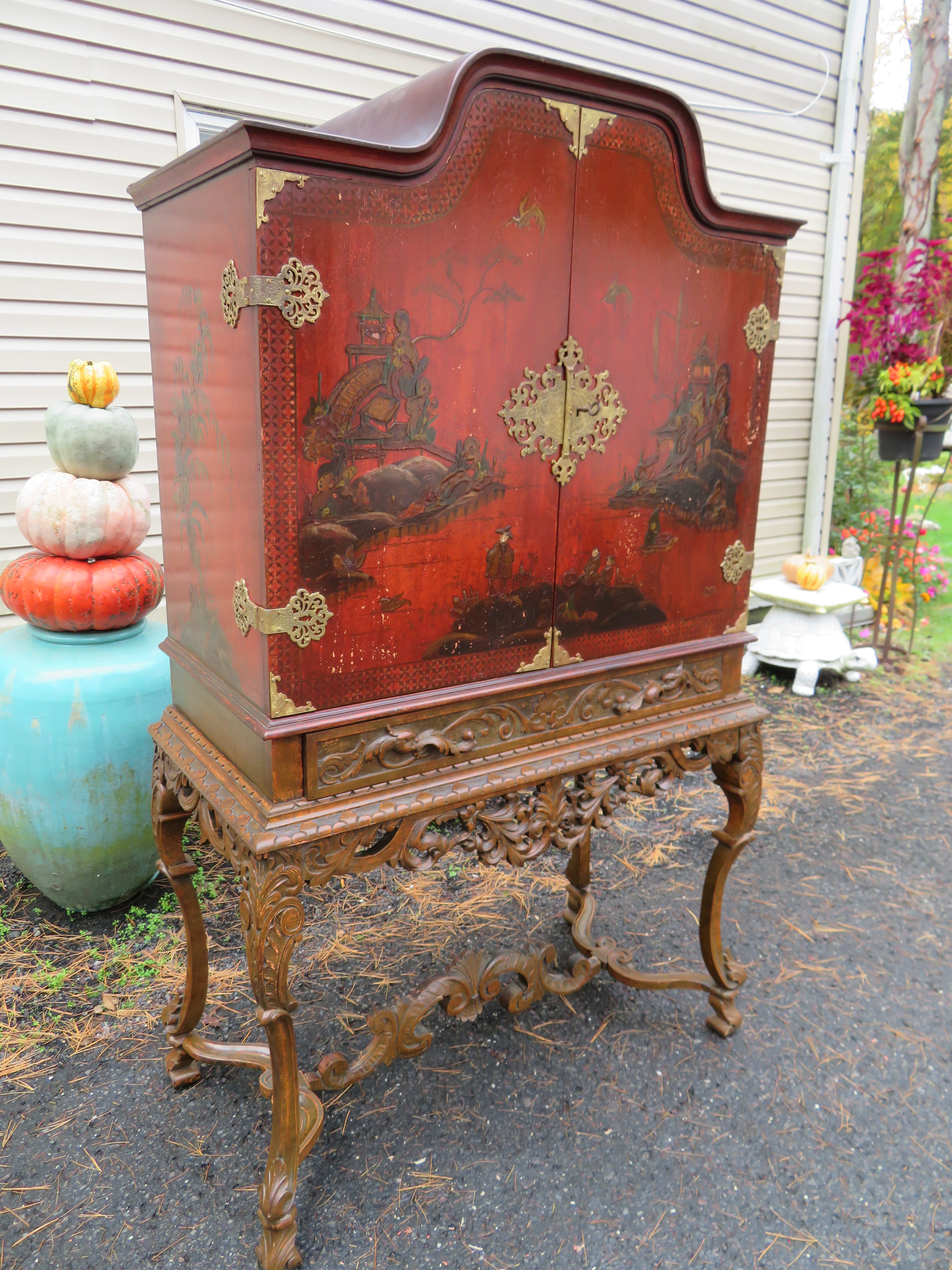 Stunning well-carved walnut Chinoiserie decorated China closet cabinet. We love everything about this beautifully decorated Chinese linen cabinet from the well-carved legs and stretchers to the handpainted case with brass hardware. There are 2