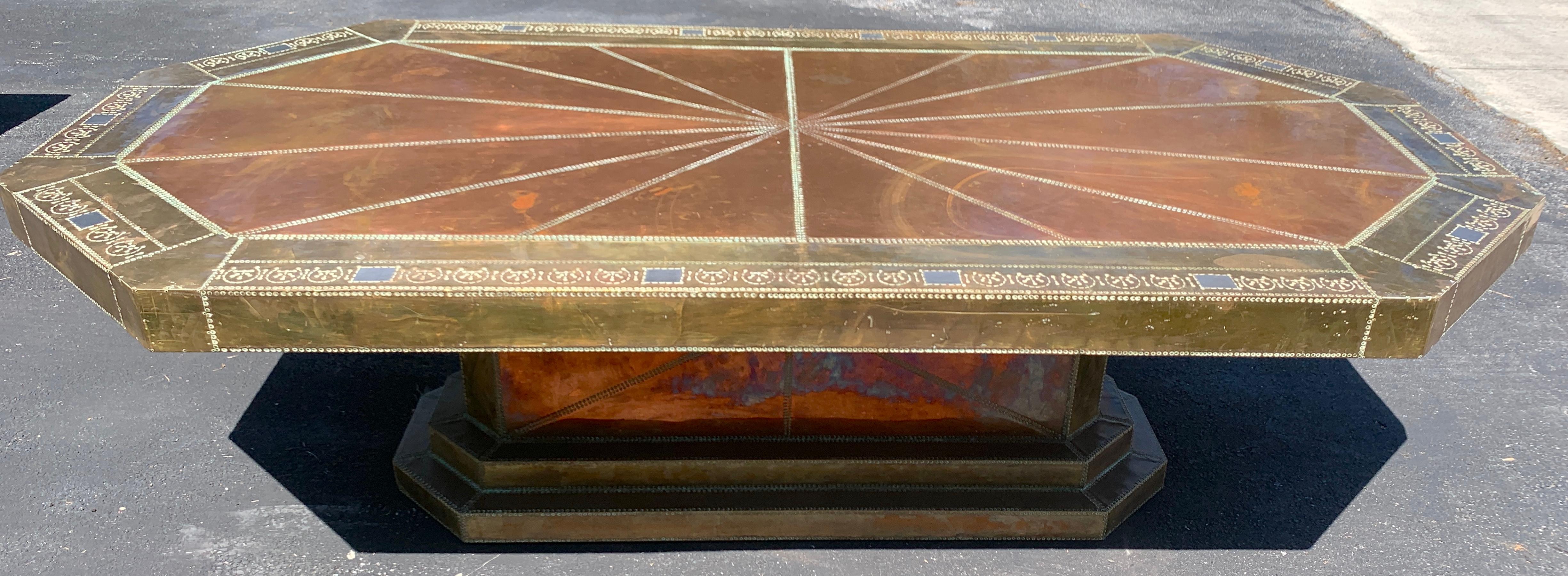 Spectacular copper and brass dining table by Rodolfo Dubarry for King Hassan II,
King of Morocco (1961-1999) in two parts, the top beautifully hand tooled in mixed metal, signed in script. Raised on a conforming riveted base.
A difficult piece to