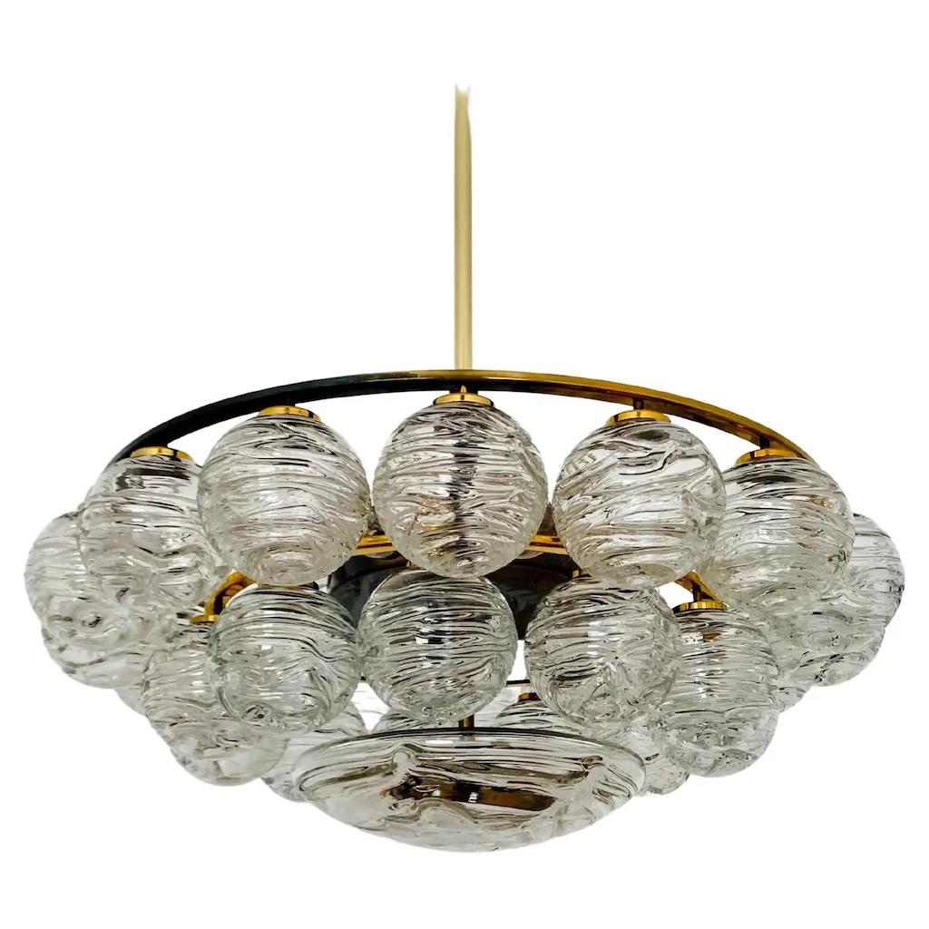 Stunning 1960's Extra large snowball flush mount ceiling fixture by Doria.
The Newly polished brass frame supports 27 beautiful swirled glass Murano snowballs and
one large center glass dome that is Stunning when illuminated.
The fixture has been