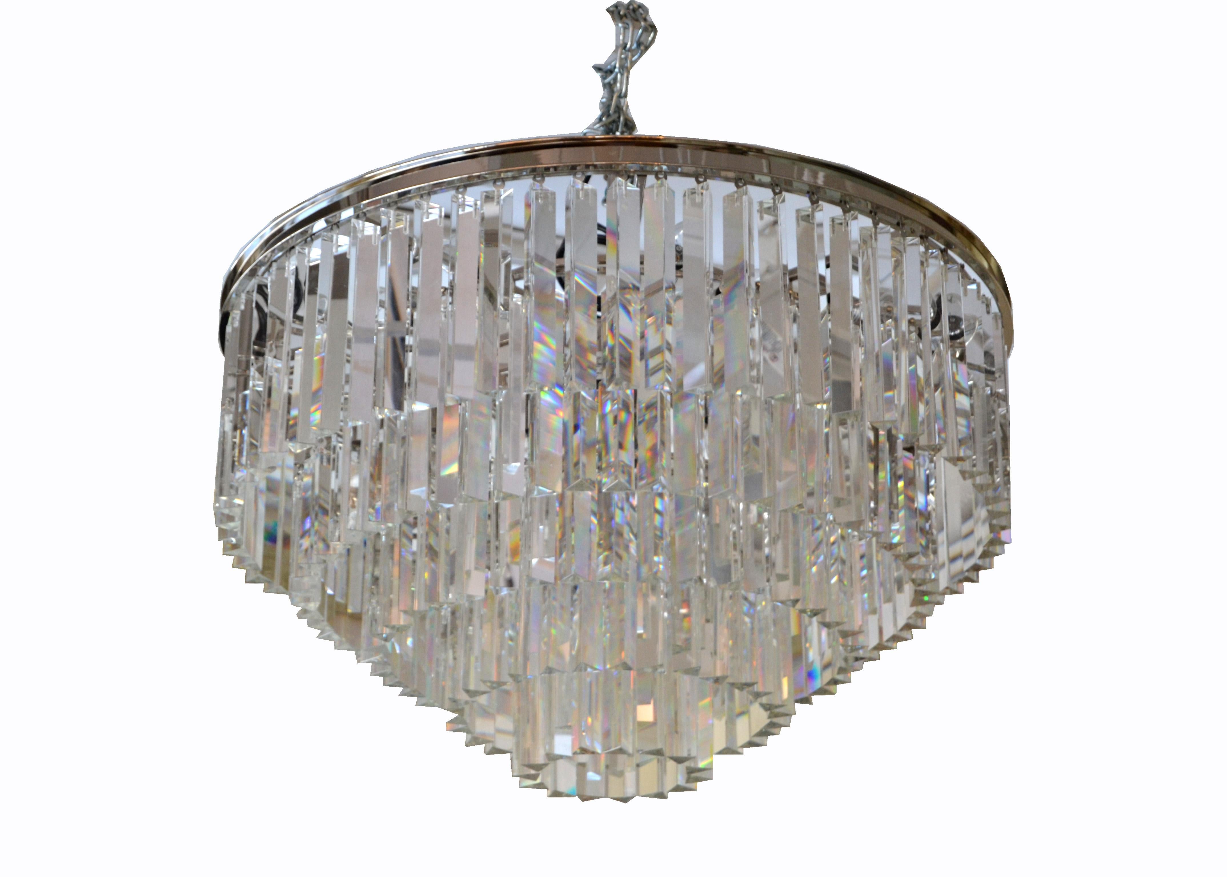 Modern spectacular five-tier chrome and mirrored crystal chandelier.
The crystals have a mirrored coating which reflects the light glamorous.
It is wired for the U.S. and uses 17 light bulbs with max. 40 watts or LED lights.
Comes with chain,