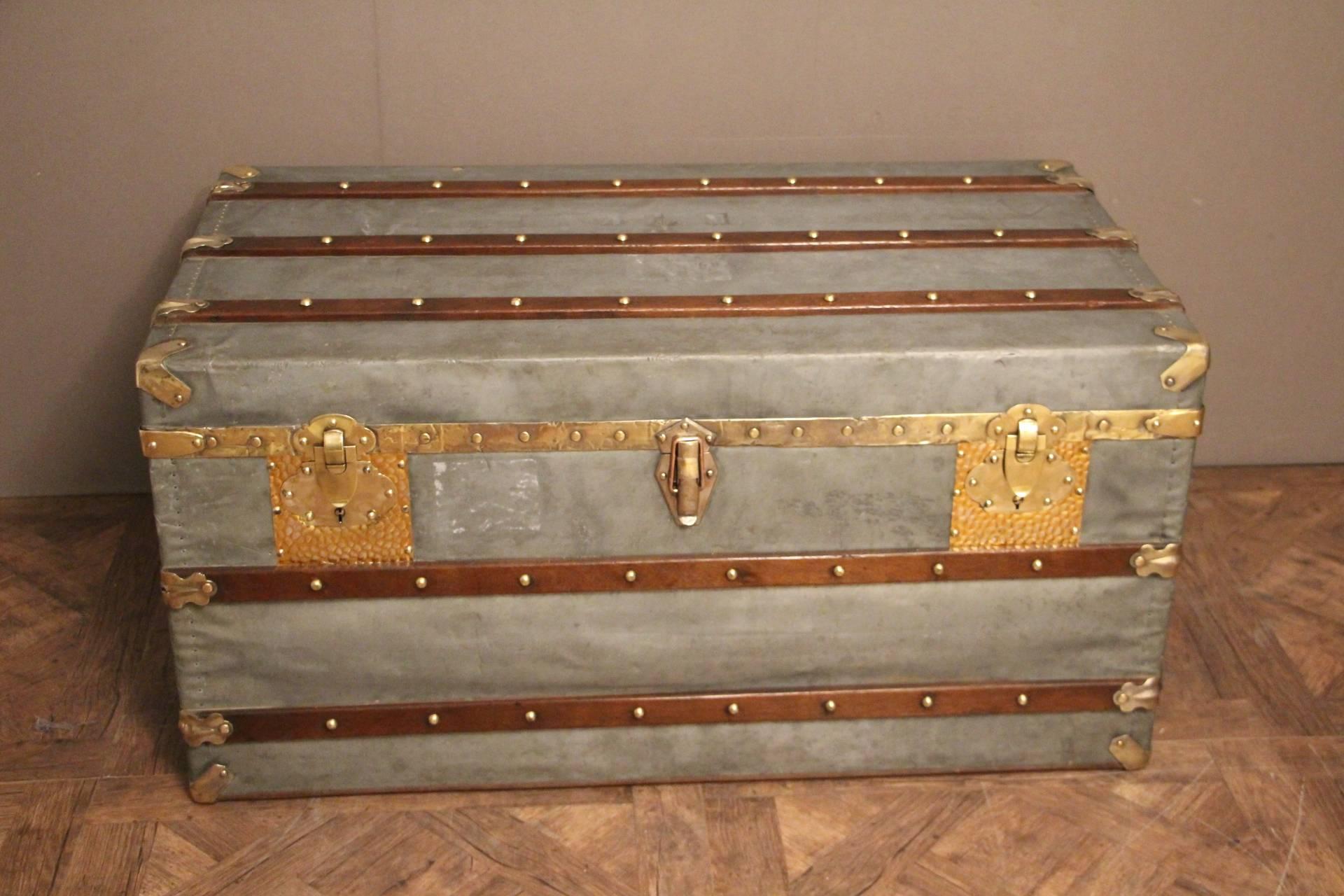 It is absolutely unusual. Its frame is wood, covered with zinc. It has got wood slats, brass and copper fittings and leather side handles.
Zinc used to be put on high end pieces of luggage that used to travel to tropical and very humid