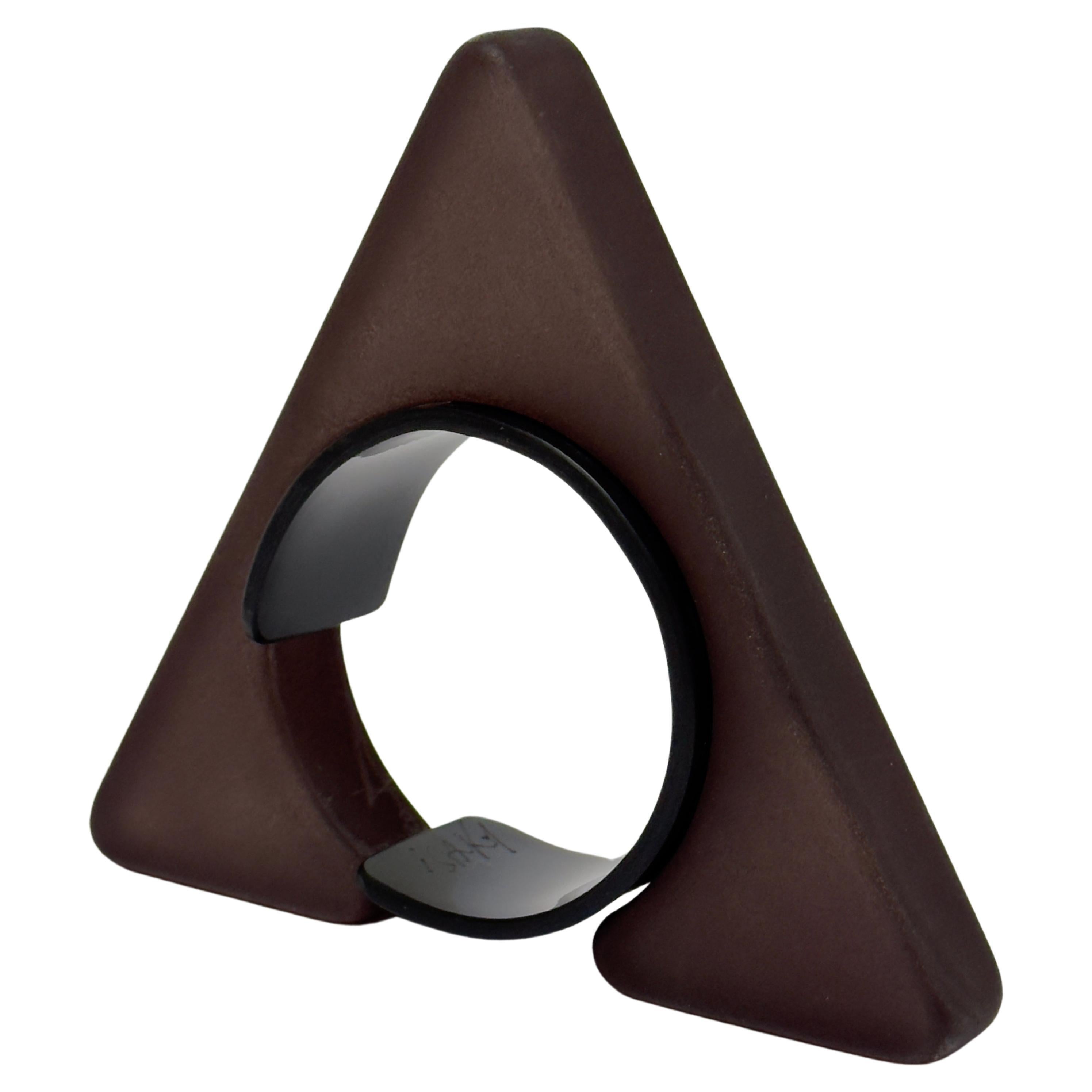 Half object, half jewel this sculptural bangle is composed of two parts ; a sand blasted resin triangle and an acrylic bracelet allowing the cuff to be closed.
Both parts bear the handwritten and engraved signature of the artist.

Measurements (cm)