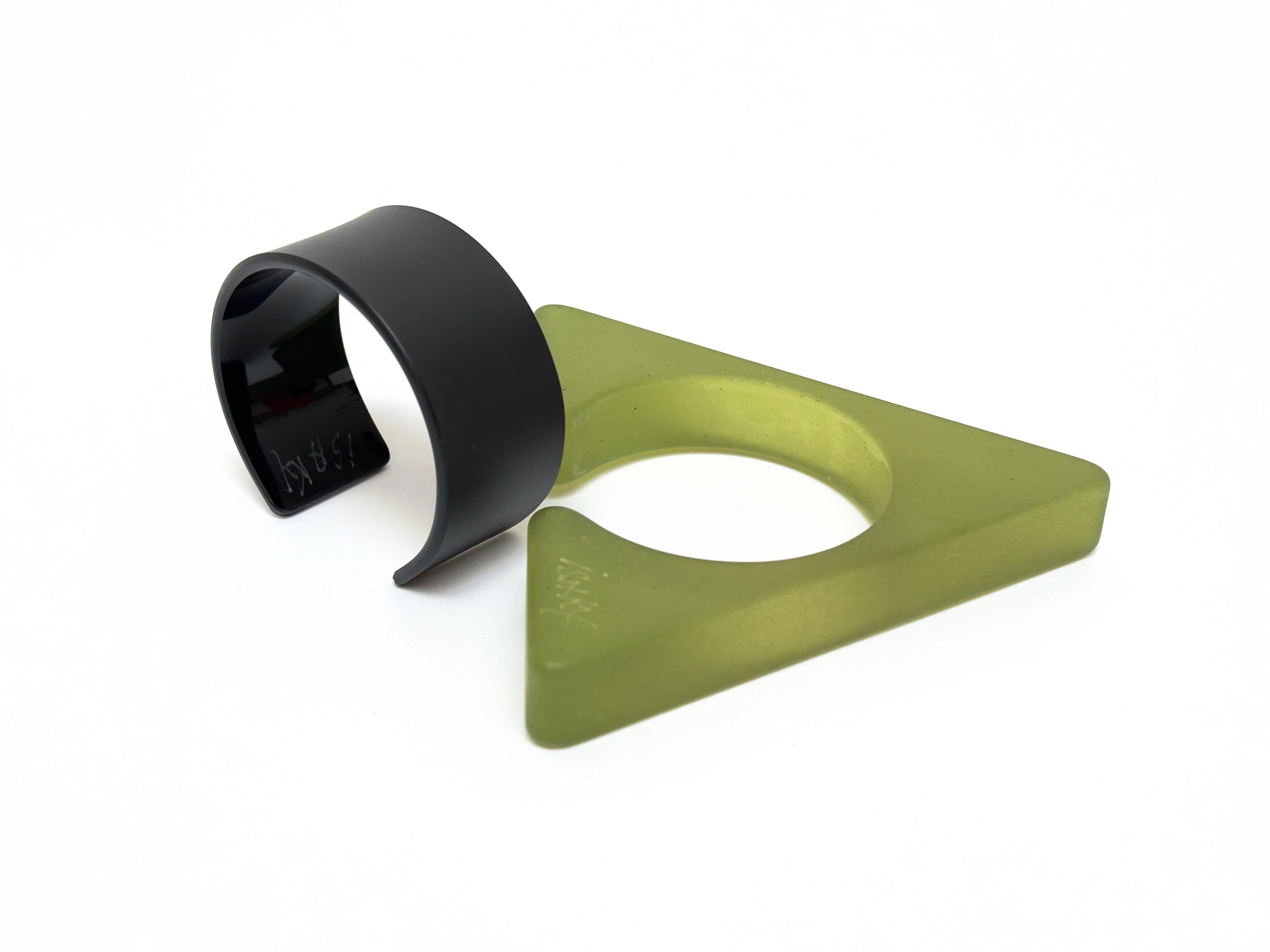 Half object, half jewel this sculptural bangle is composed of two parts ; a sand blasted resin triangle and an acrylic bracelet allowing the cuff to be closed.
Both parts bear the handwritten and engraved signature of the artist.

Measurements (cm)