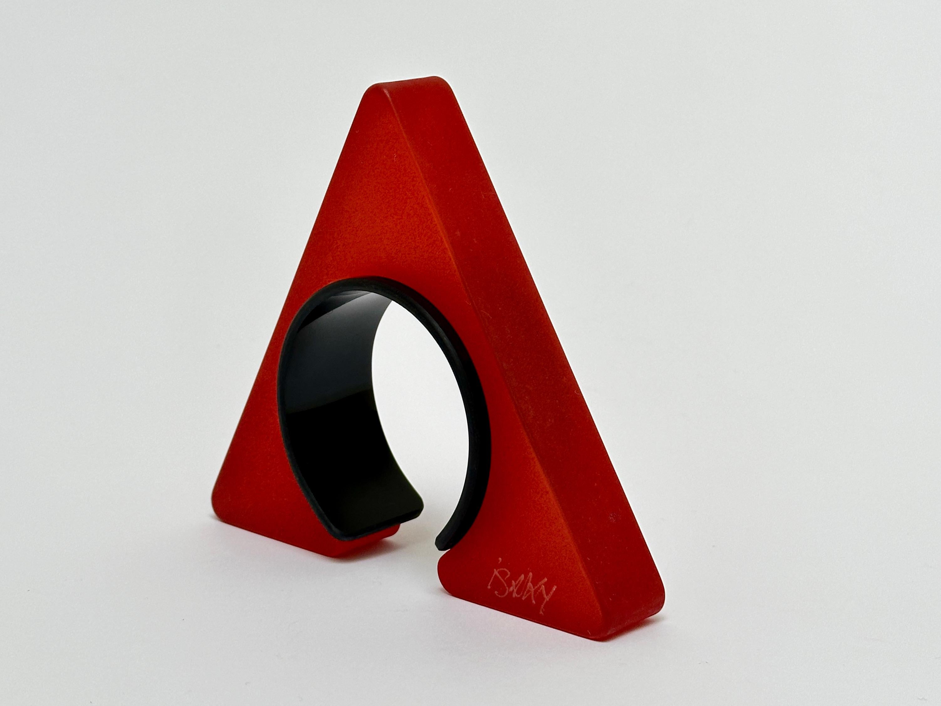 Half object, half jewel this Sculptural bangle is composed of two parts ; a sand blasted resin triangle and an acrylic bracelet allowing the cuff to be closed.
Both parts bear the handwritten and engraved signature of the artist.

Measurements (cm)