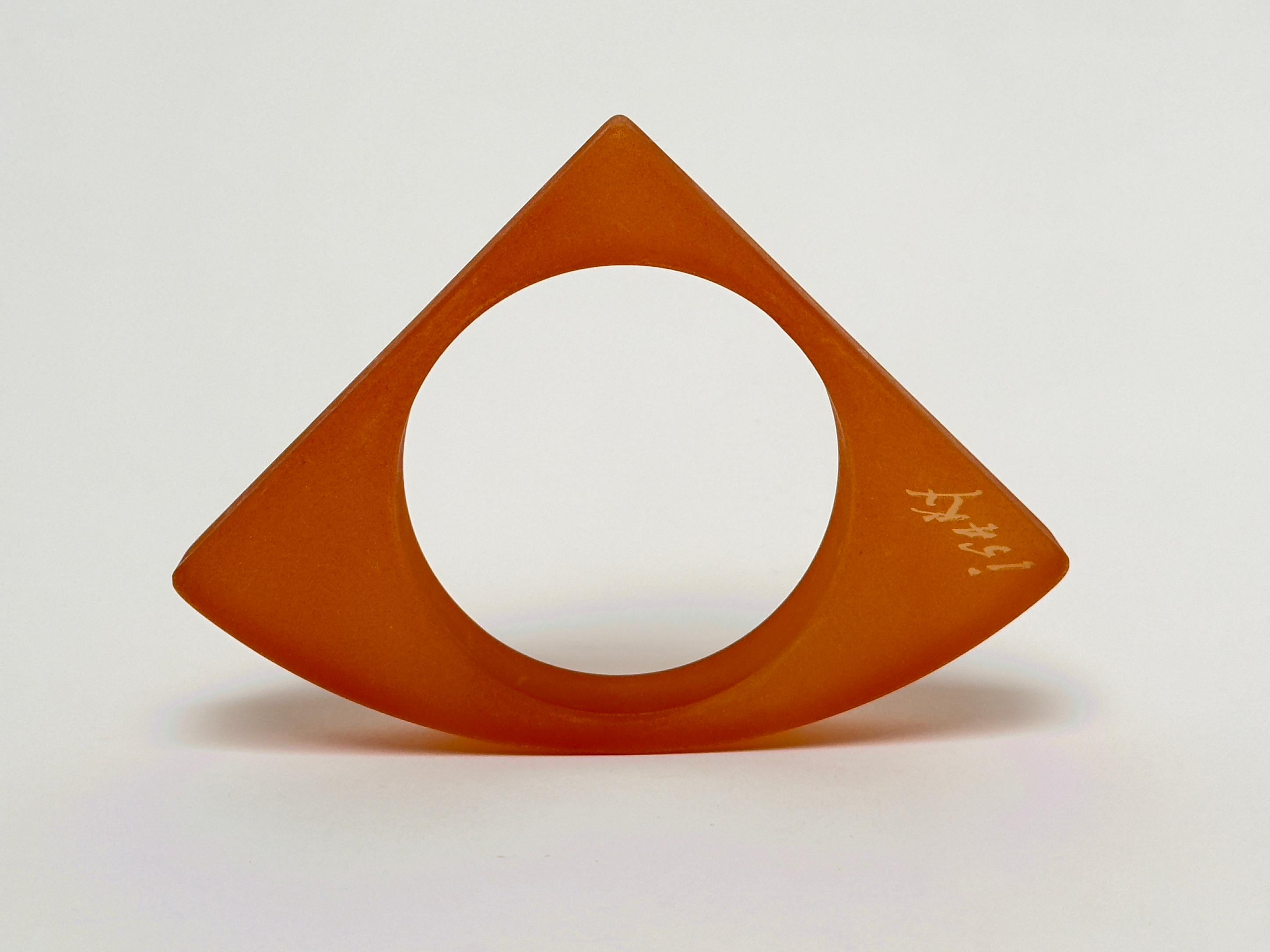 Half object, half jewel, this sculptural bangle in sandblasted resin bears the handwritten signature of the artist.

Measurements (cm) :
triangle's sides 9.8 
depth 2 
wrist (int. diam.) 6.5

Former engineer, Isaky settles his reputation as a jewel