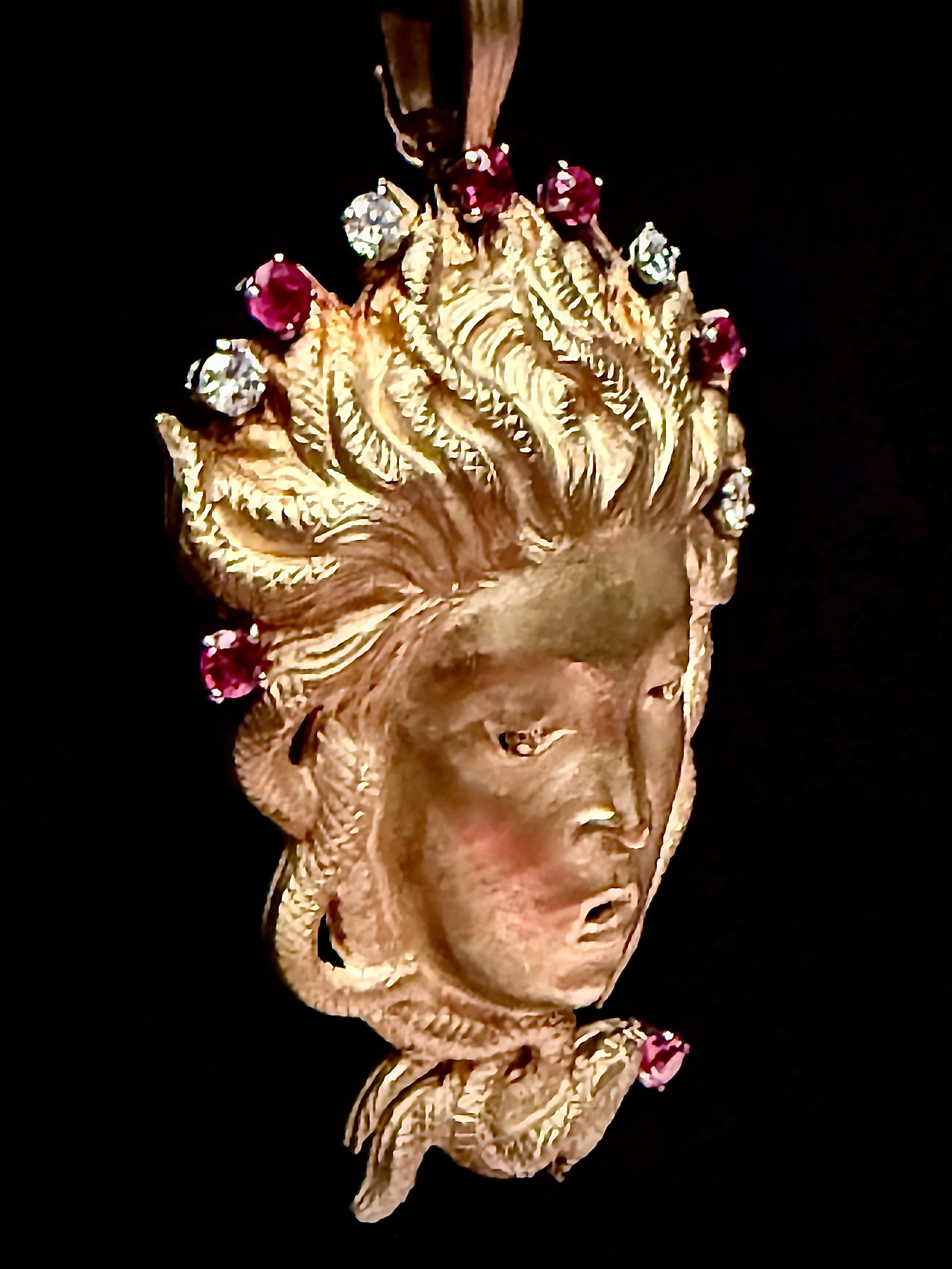 This is really special very large 18-19kt gold Medusa face pendant with faint green overtones. It has a matte finish with lightly polished highlights. There is a halo of six rubies and four diamonds. The diamonds are of substantial size and bright