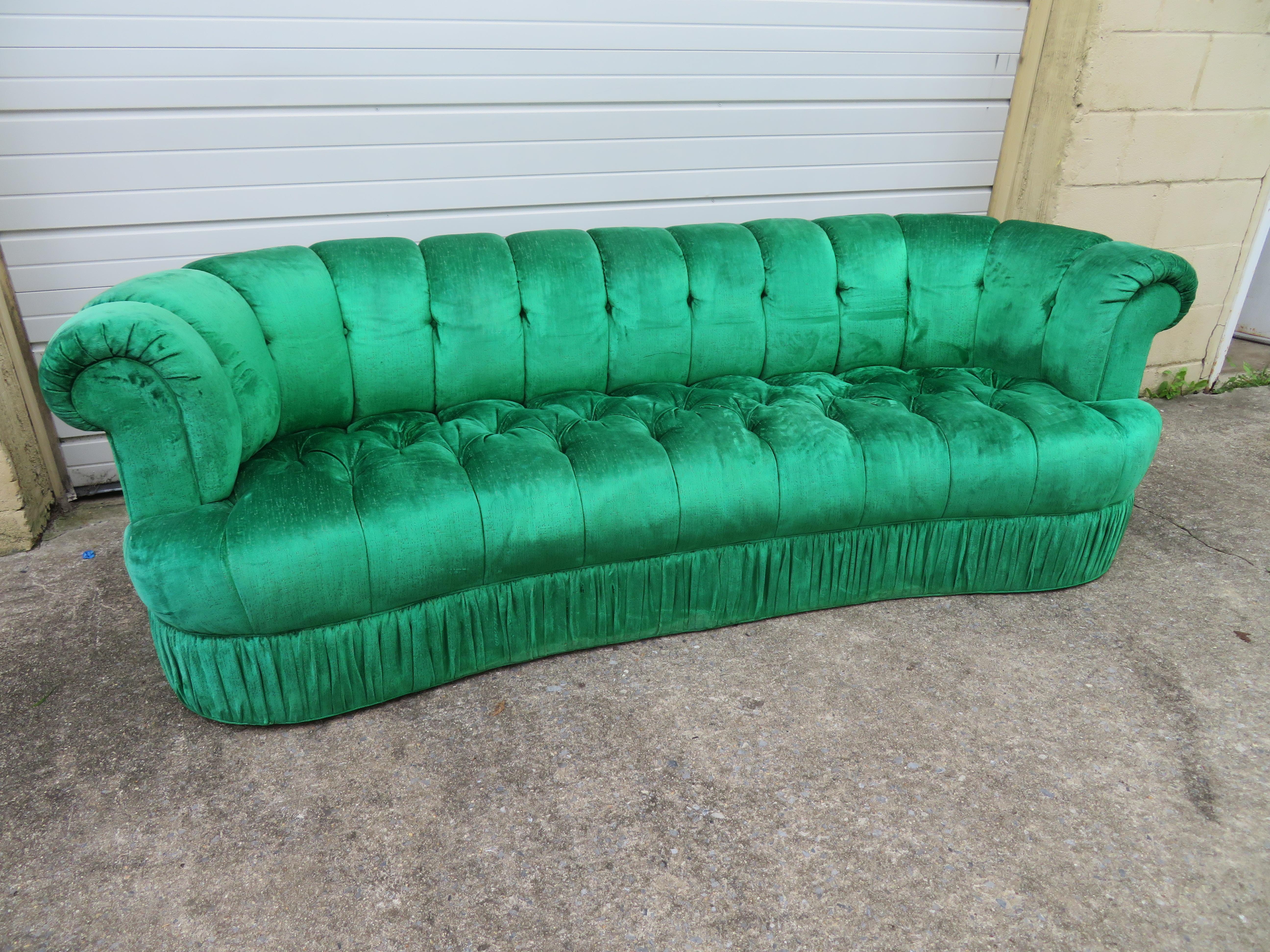 Spectaculaire canapé touffeté en forme de rein de Hollywood Regency. Cette pièce est un véritable bijou vintage des années 1970, tapissé d'un magnifique velours vert émeraude. Le tissu est toujours dans un état fabuleux et est tout simplement