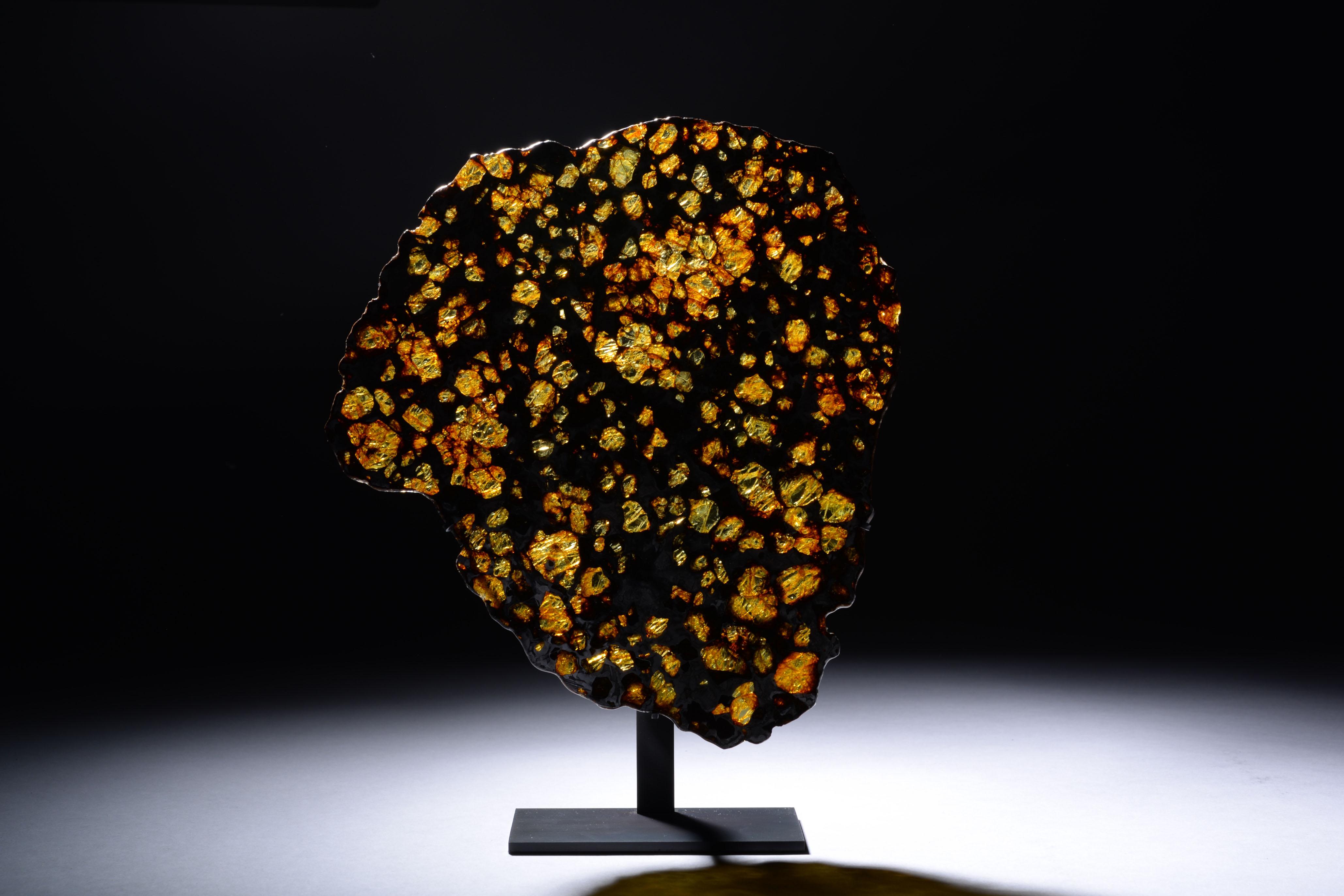 “This 282 g interior section of the Imilac pallasite shows a large range of olivine grain sizes – there are coarse grains, grain clusters and fine-grained, crushed olivine debris. All of the olivine grains are surrounded by a matrix of metallic