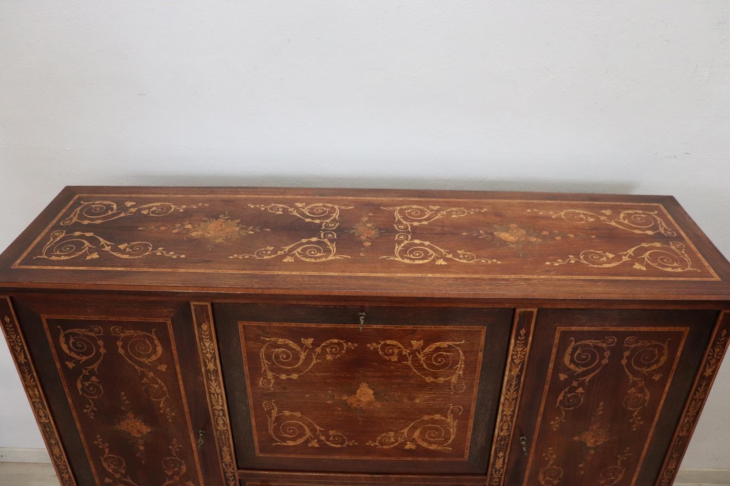 Elegant sideboard in precious inlaid walnut 1930s. This sideboard is characterized by a refined inlay work with neoclassical decorations. Beautiful with flowers decorate each side of this precious piece of furniture. The inlay is made using many