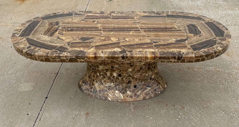 Stunning rare artisan handcrafted 1980s Muller's of Mexico veneered brown Oynx large oval racetrack dining or conference table on a sculpted pedestal base. The top has carefully selected book matched Onyx veneer slices applied to a plywood substrate