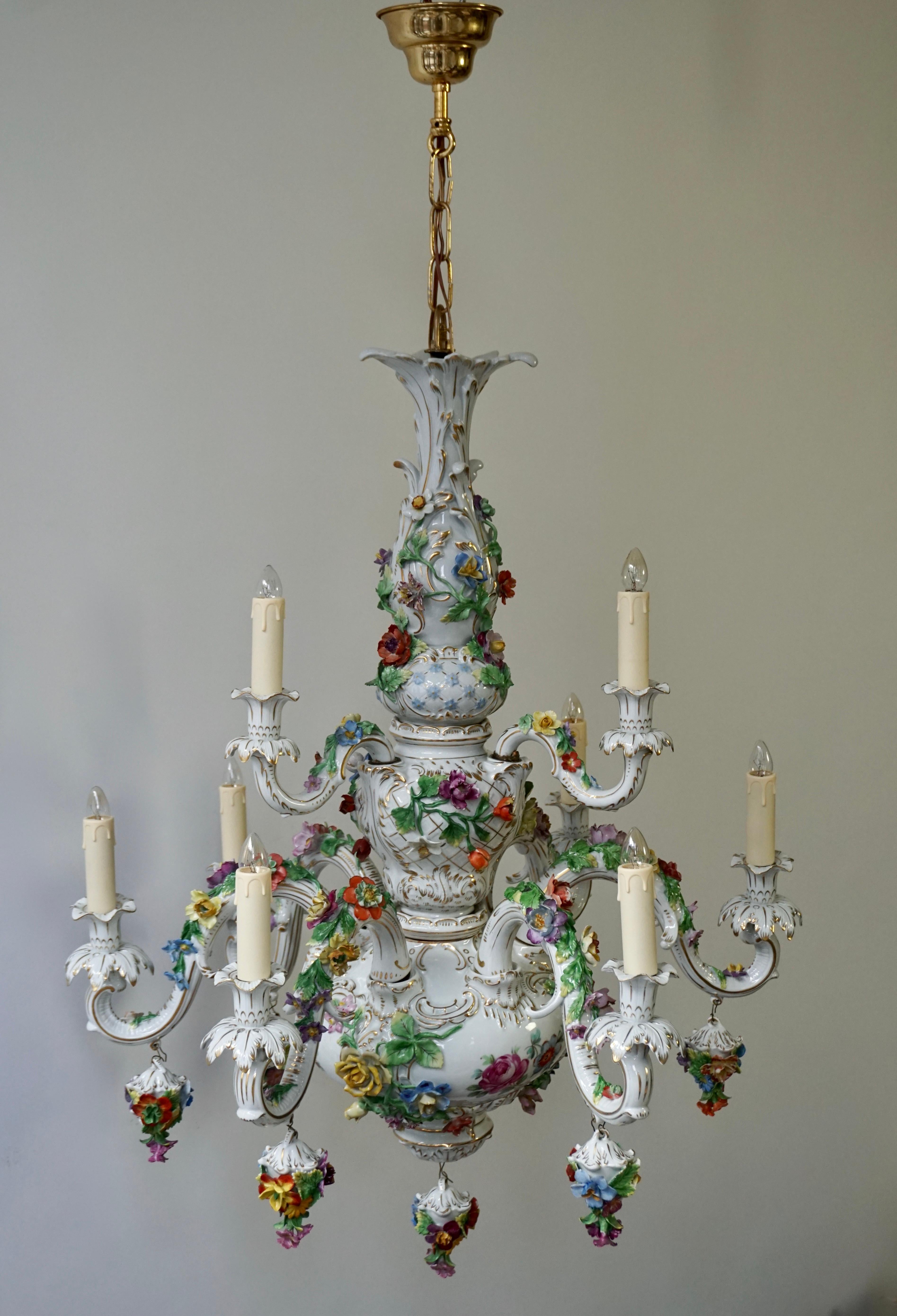 Blanketed in a multitude of floral bouquets, this monumental porcelain chandelier was possible crafted in Italy or Germany. A marvellous example of exceptional artistry, this enchanting tole multi light double tier 9-light fixture exemplifies the