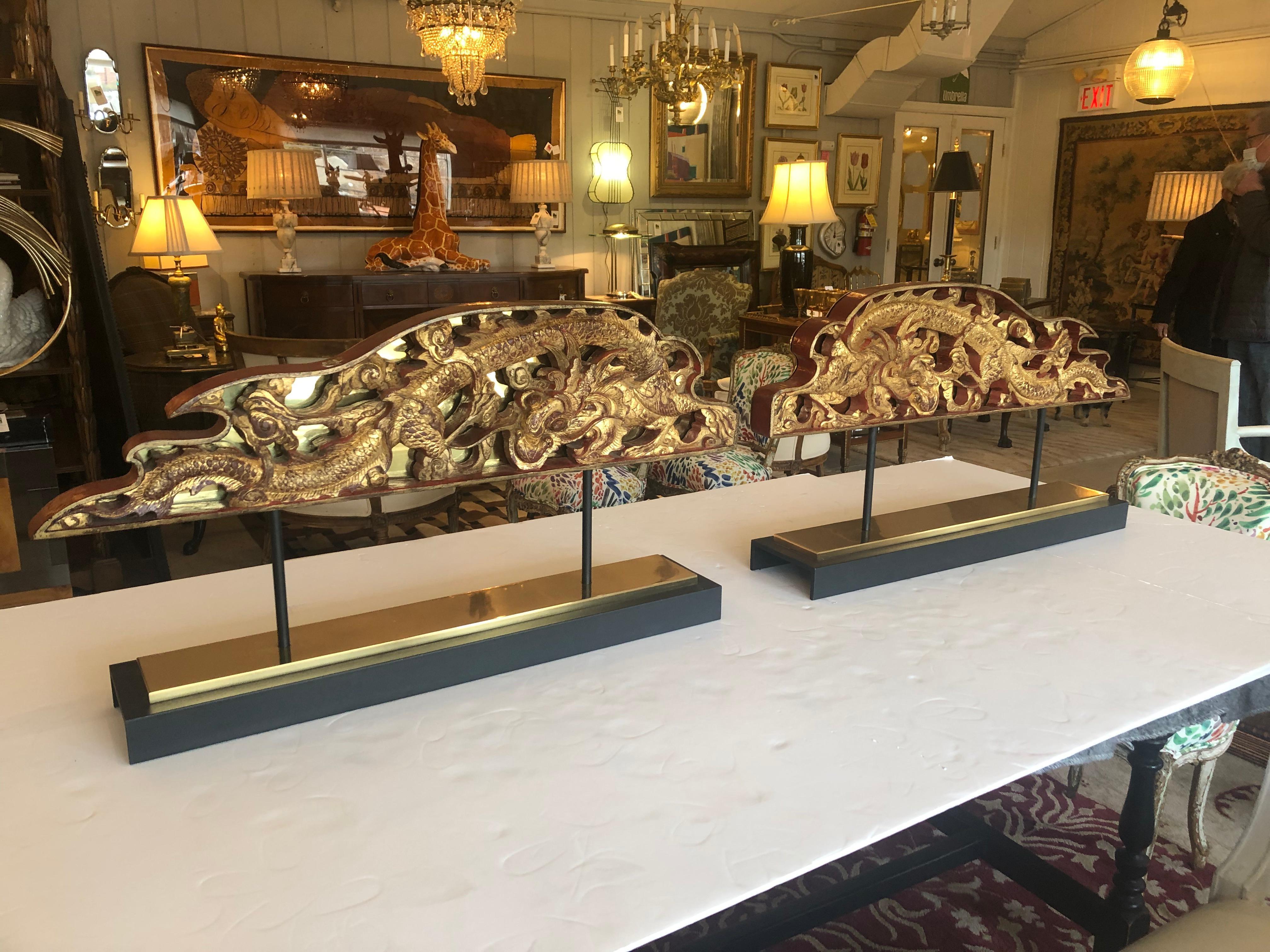 A sensational dramatic pair of tabletop sculptures made from carved laquered and gilded Chinese architectural fragments having dragons and ornate decoration, each backed in brass and mounted on custom iron and brass stands. Original wax seals on