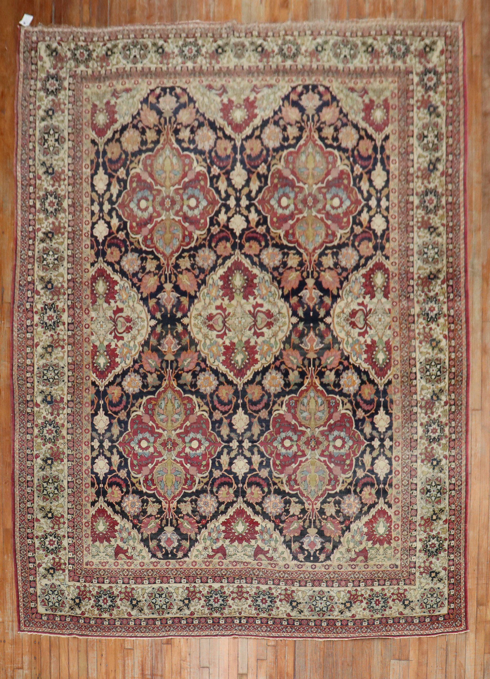 Phenomenal early 20th century antique Persian Kerman rug with a large scale all over design on a navy ground. Sparkling accents in plum, raspberry, beige, light blue and pink.

Measures: 9'1