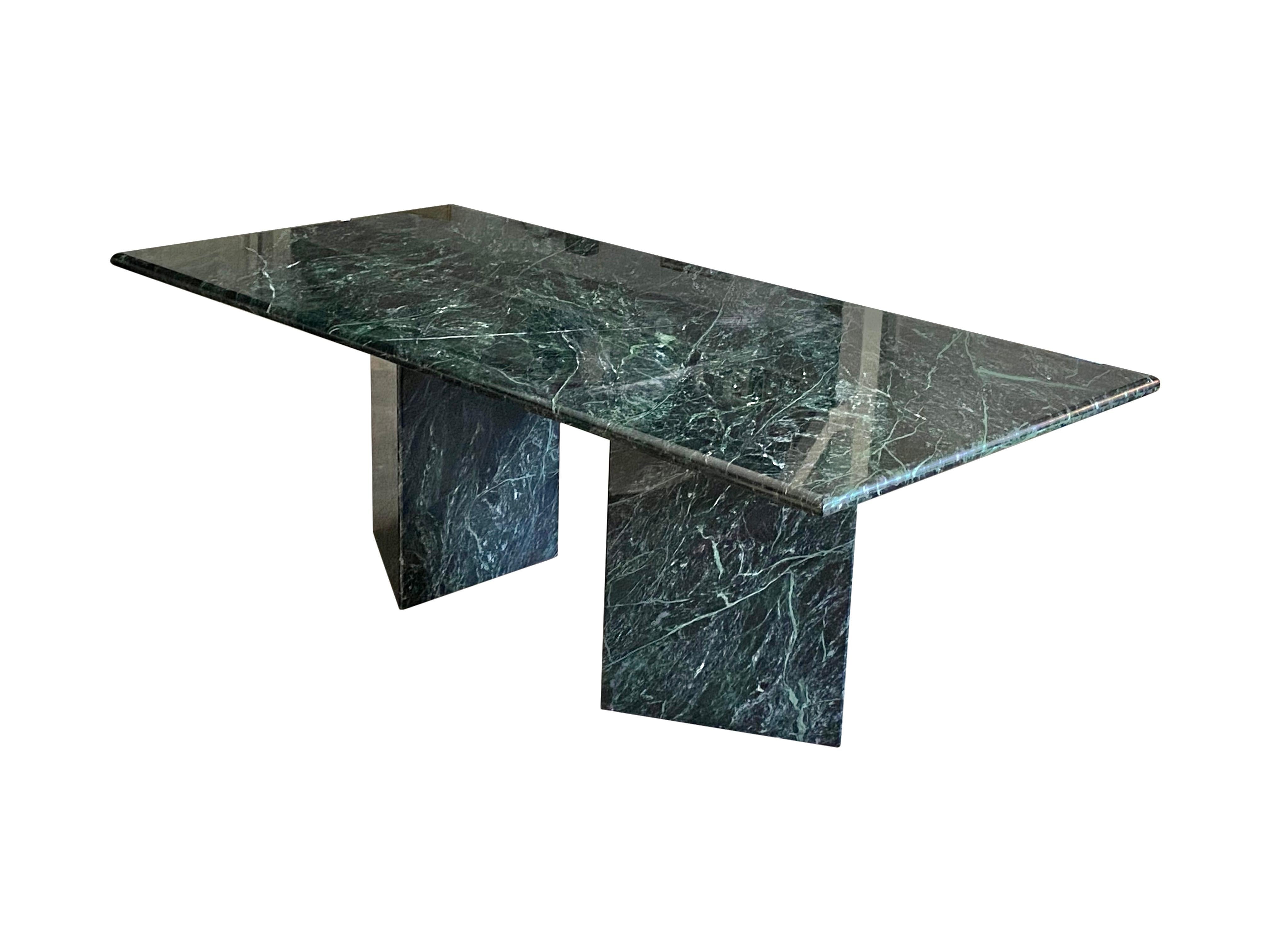 Incredible dining table in green marble. Rectangular shape allows for up to 8-10 dining chairs. Bullnose edge softens the sides and creates a stunning effect. No dings or fading. Marble in good condition. Top rests upon triangular marble pedestals