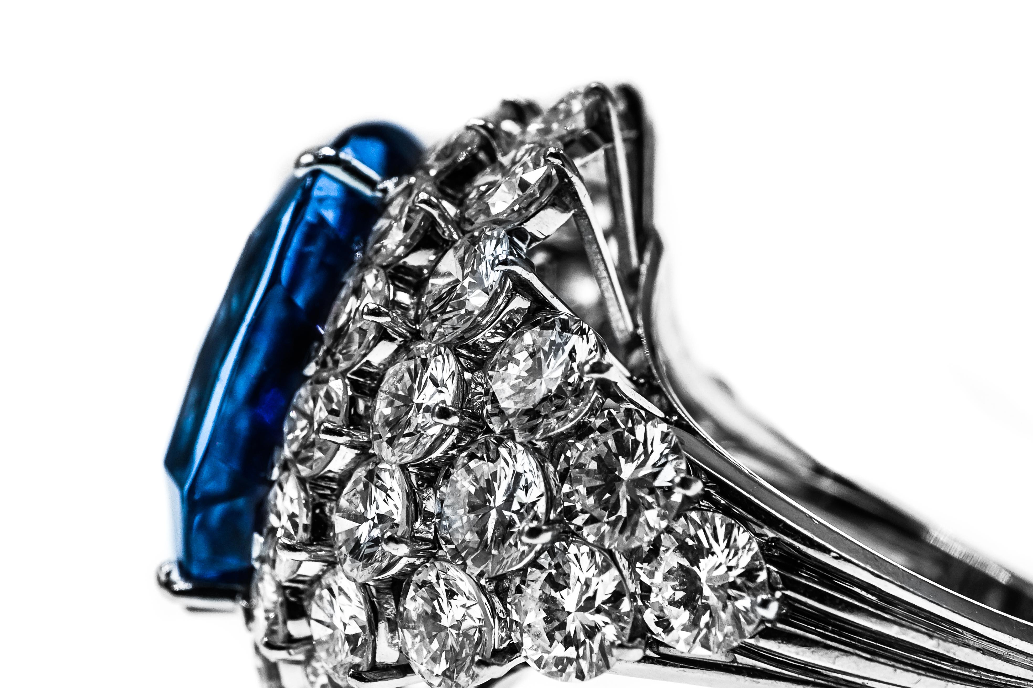 Spectacular Massive Sapphire and Diamond Ring, France
Centering one cushion-shaped sapphire approximately 46.31 cts., surrounded and flanked by 48 round diamonds approximately 11.80 cts., with makers mark and French assay mark, approximately 18