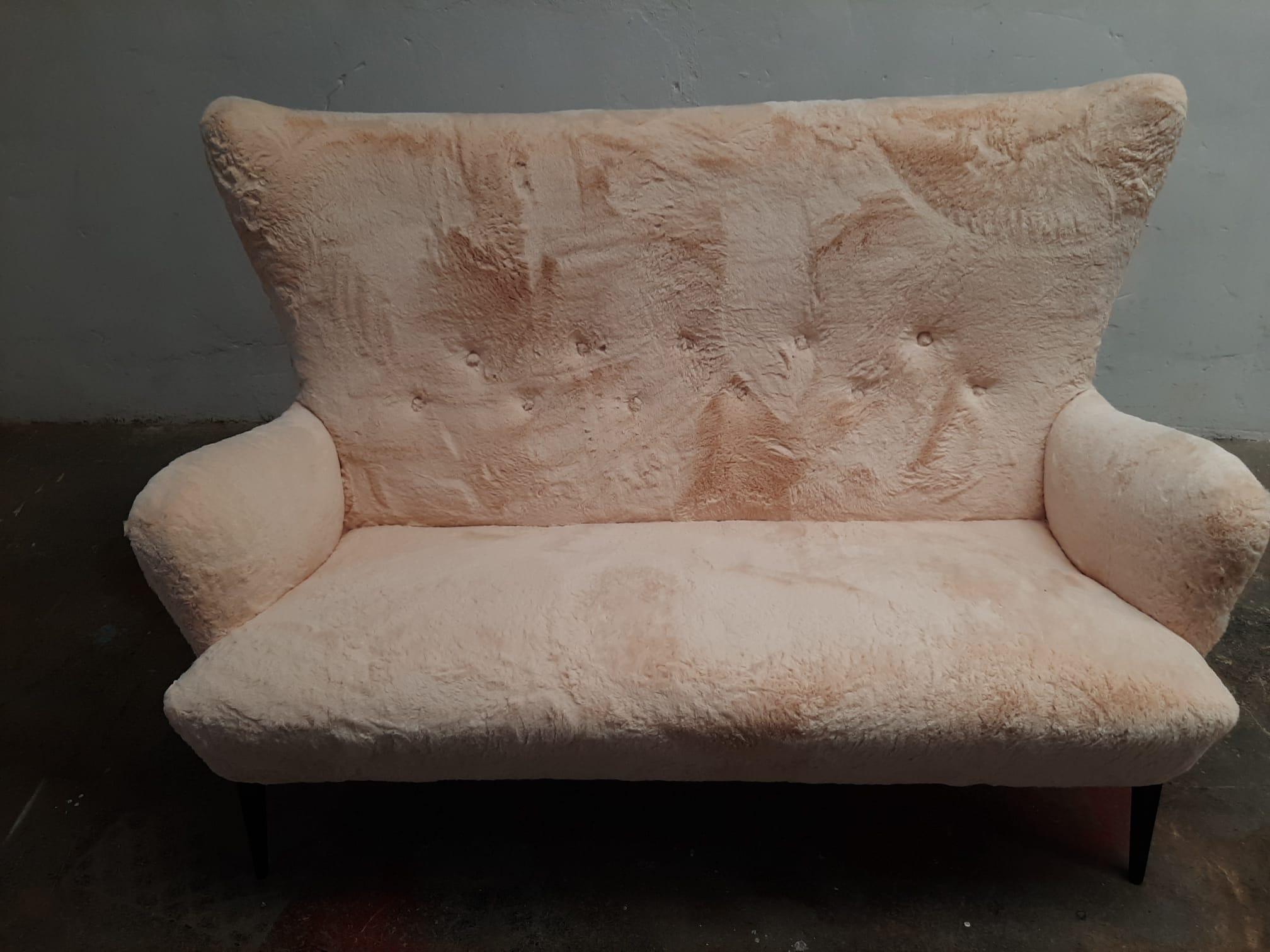 Vintage Italian Iconic sofa from the 1950s with a very characteristic design of the time, black lacquered needle legs, luxurious upholstered in a cream colored short pile, very soft & warm to the touch and finished with aged studs.

Approx.