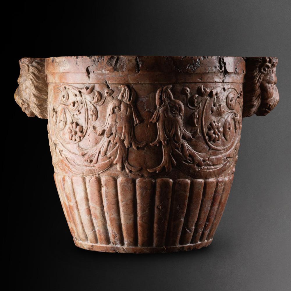 The mortar is of exceptional quality. The sculptural execution of the carved decoration is appealing. Large scrolls of leaves terminate in stylized eagle heads. The sides are adorned with carved lion masks and the lower body is decorated with round