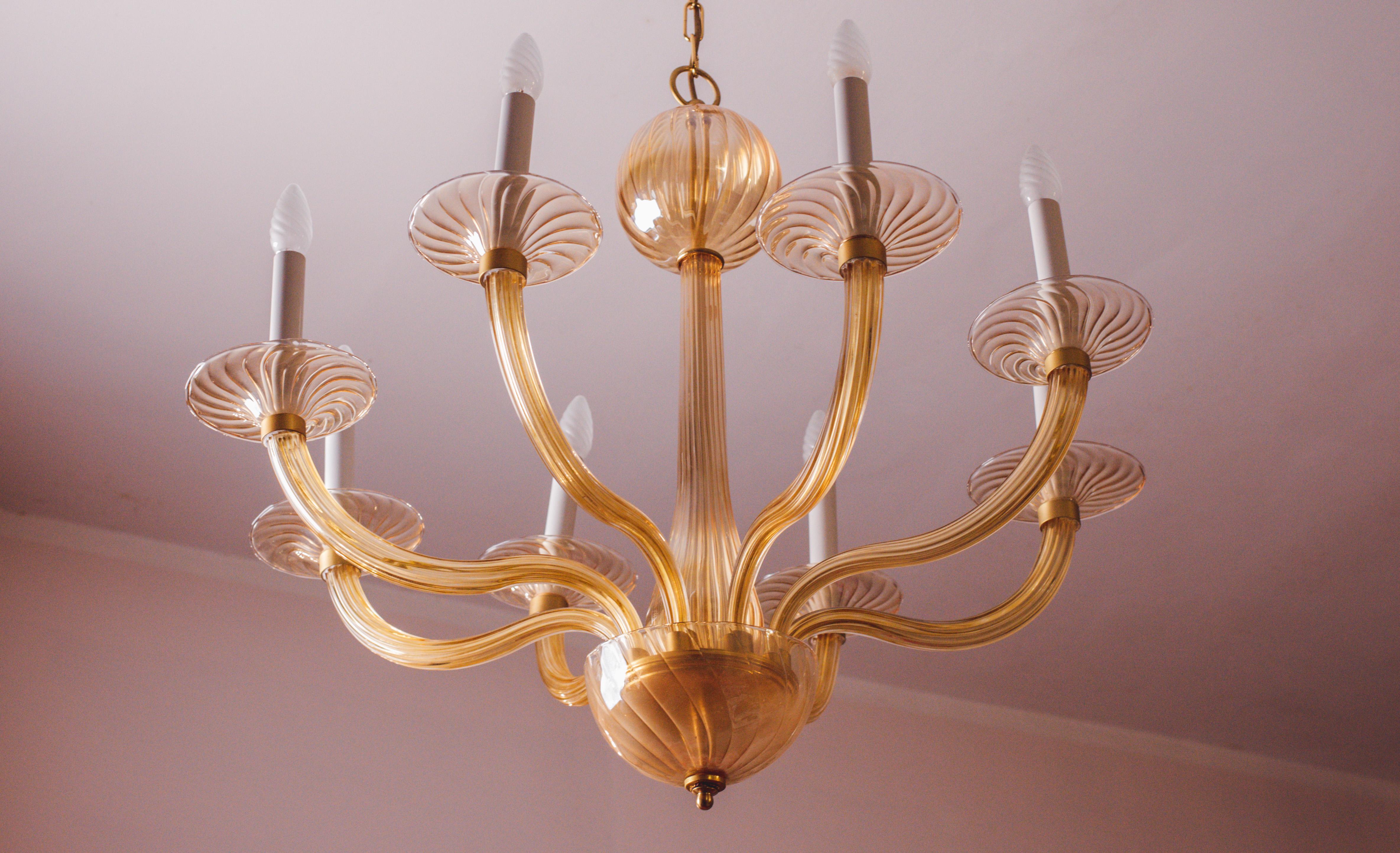 Spectacular Murano chandelier from 1970 with 8 amber-coloured arms.
The chandelier is 110 cm high with the chain, without chain it measures 75 cm, the diameter measures 90 cm.
The chandelier currently mounts 8 e14 bulbs.