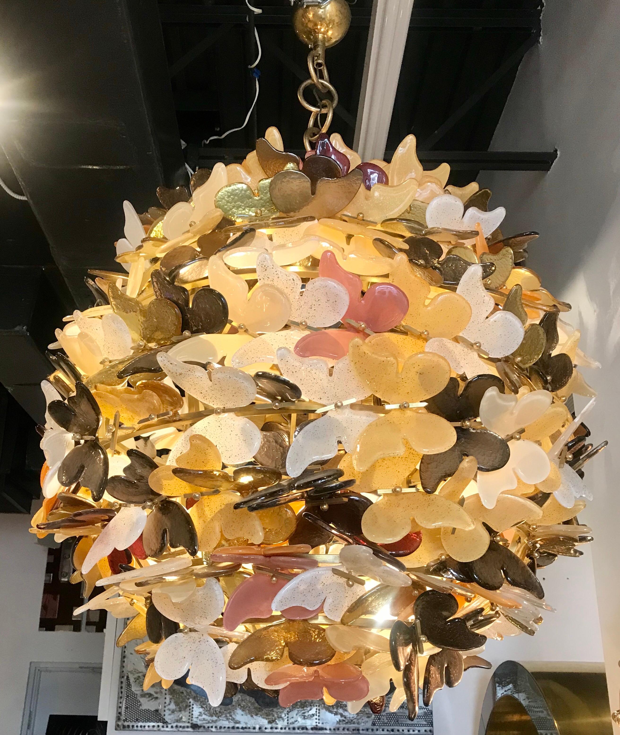 A large breathtaking Murano glass Italian globe chandelier that was rewired in Italy. Each butterfly is unique and some have gold inclusions creating a beautiful array of color and texture. The butterflies are poised on a brass globe and look as if