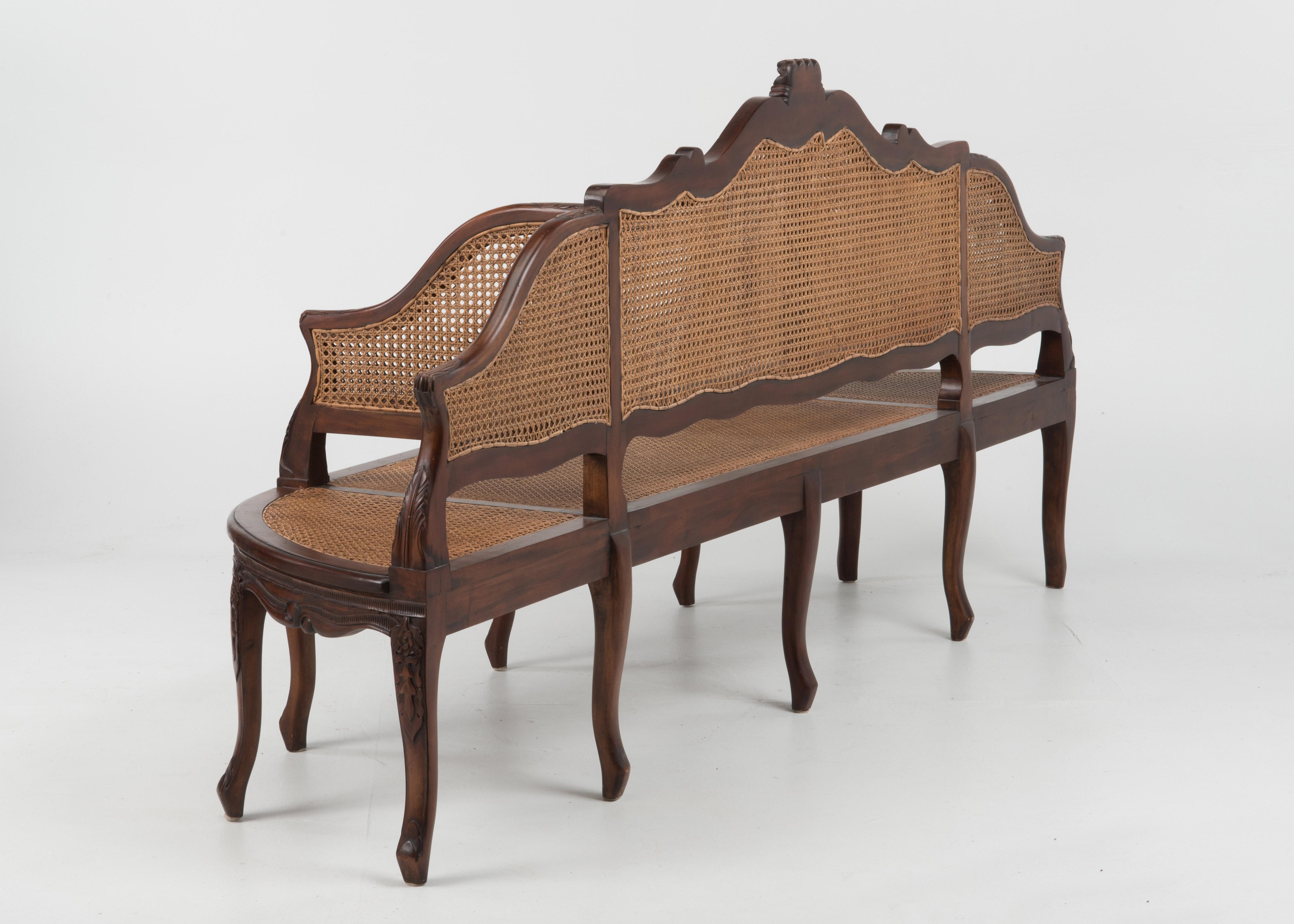 A spectacular Italian carved mahogany and double caned bench settee in 3 sections, having a central middle section 48