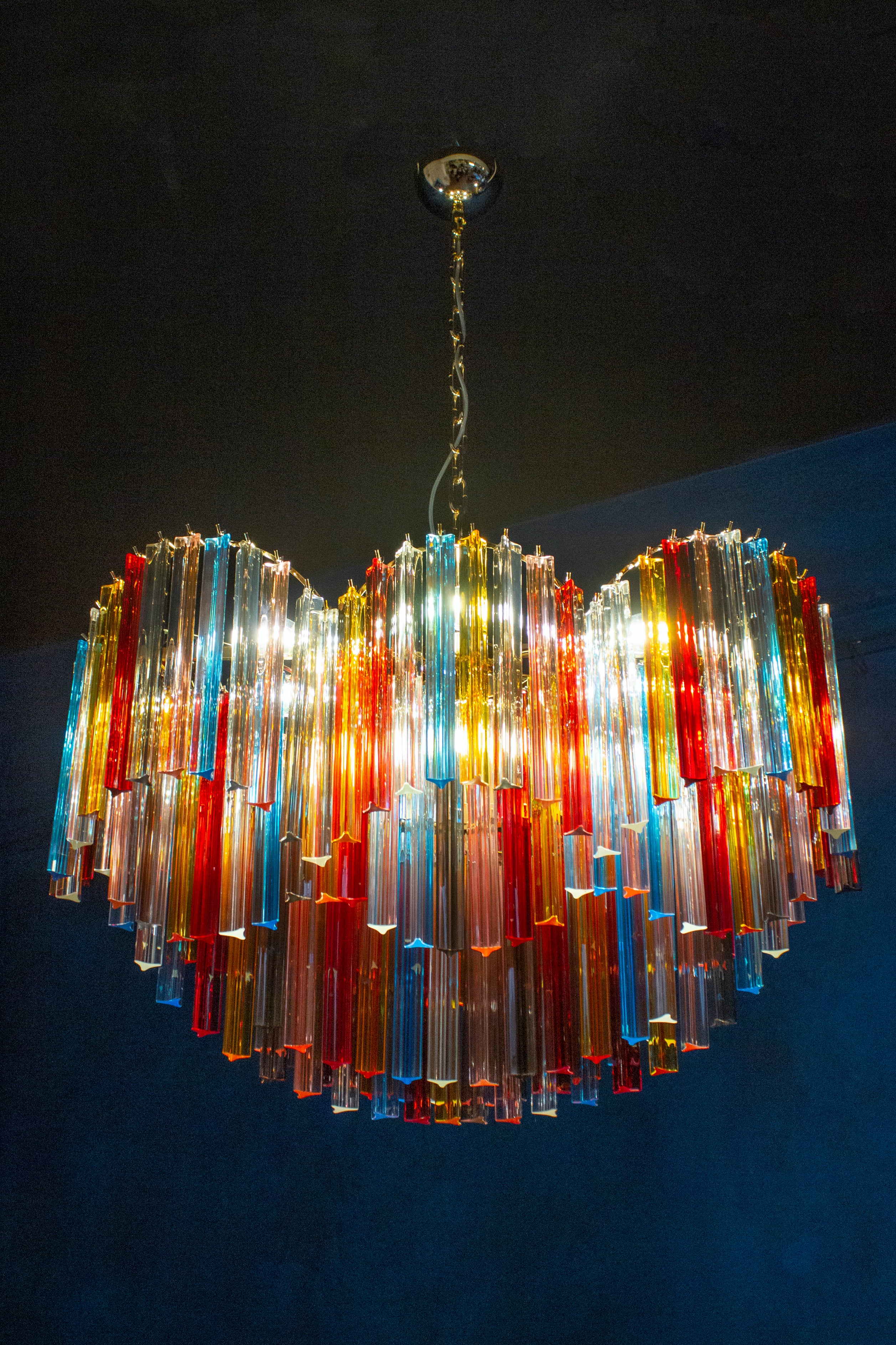 Outstanding Murano chandelier made by Murano crystal multicolored triedi prism on four levels with a gold metal frame.
The glasses are Aquamarine, transparent, blue, smoky, purple, yellow, pink and orange , creating a fabulous light effect.
 We