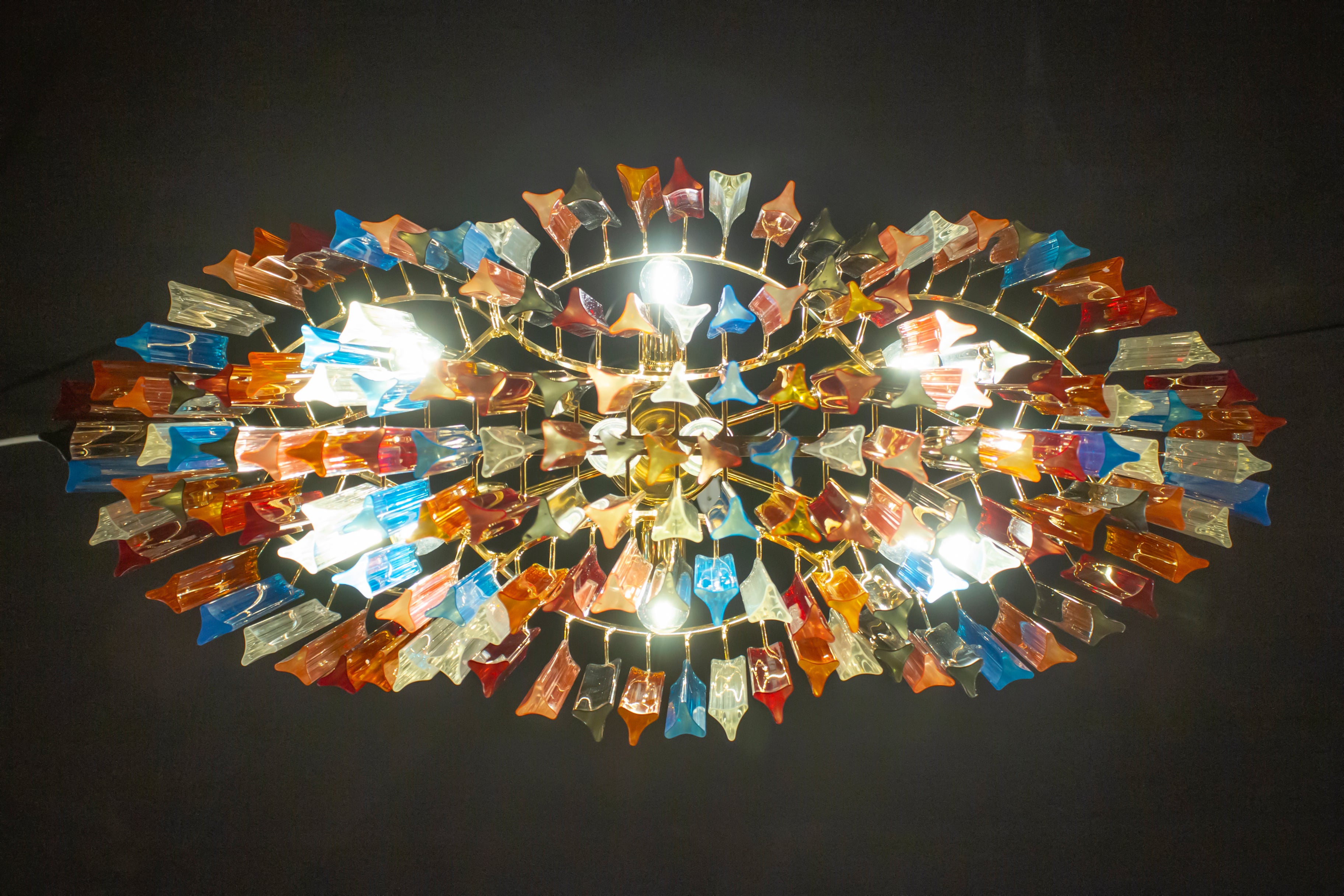 Outstanding Murano chandelier made by Murano crystal multicolored triedi prism on four levels with a gold metal frame.
The glasses are Aquamarine, transparent, blue, smoky, purple, yellow, pink and orange , creating a fabulous light