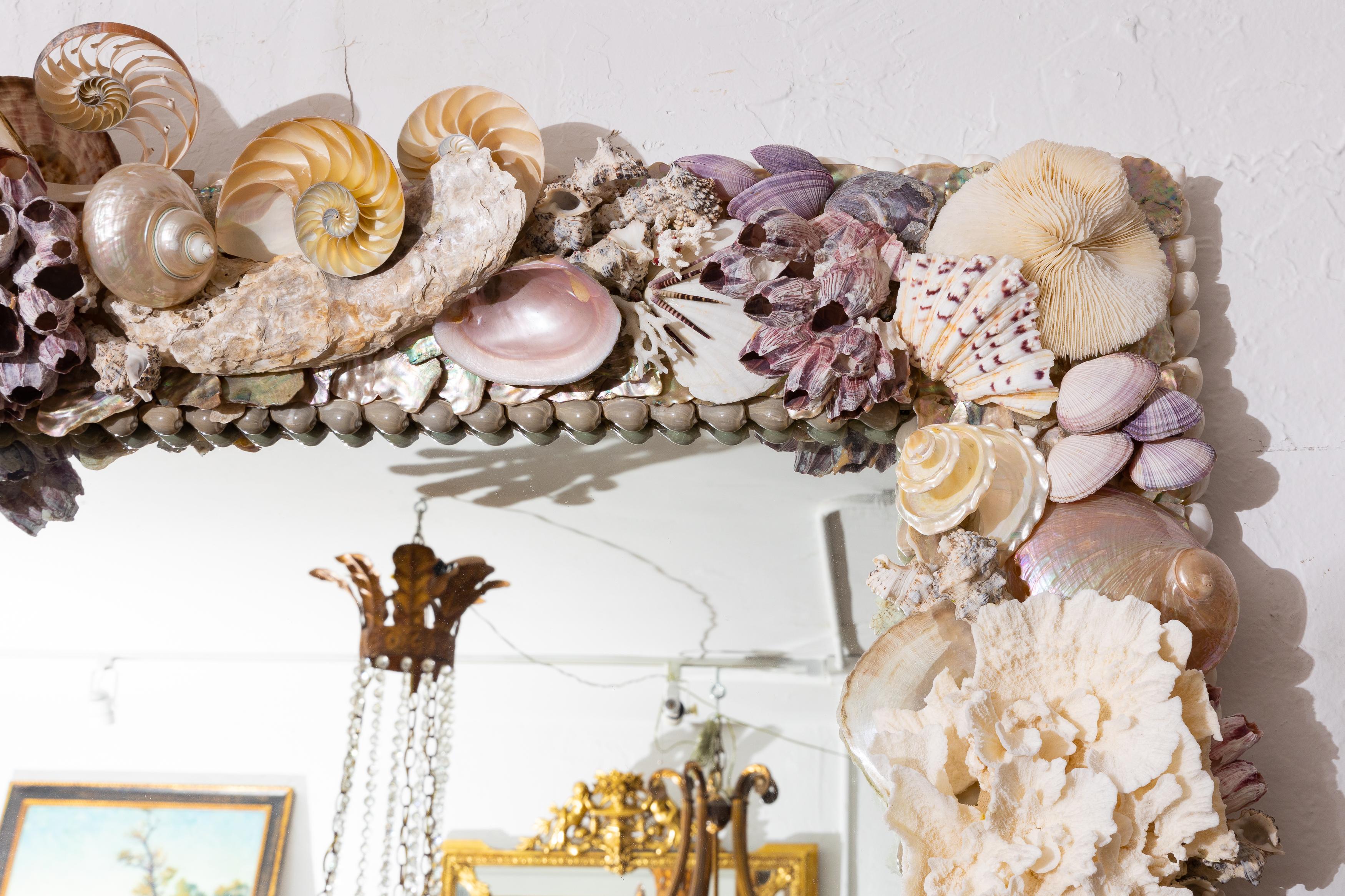 This is an exceptional and dramatic custom mirror, the frame encrusted with a myriad of unique shells and coral.