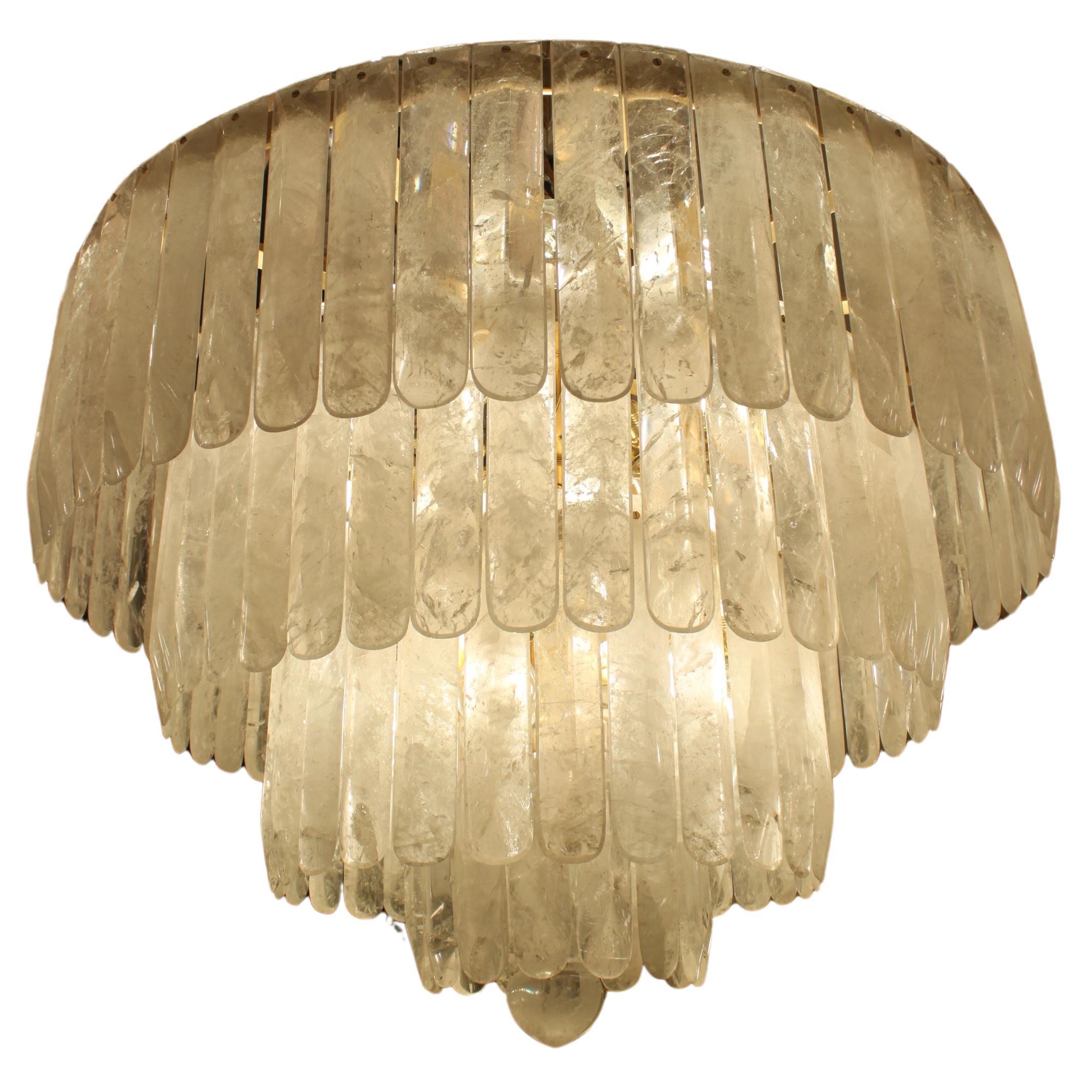 A beautiful pair of rock crystal chandeliers comprising 4 bronze circular reducing tiers each profusely hung with a total of 135 individually hand carved rock crystal drops. A beautiful solid rock crystal pear drop hangs below to add a finishing