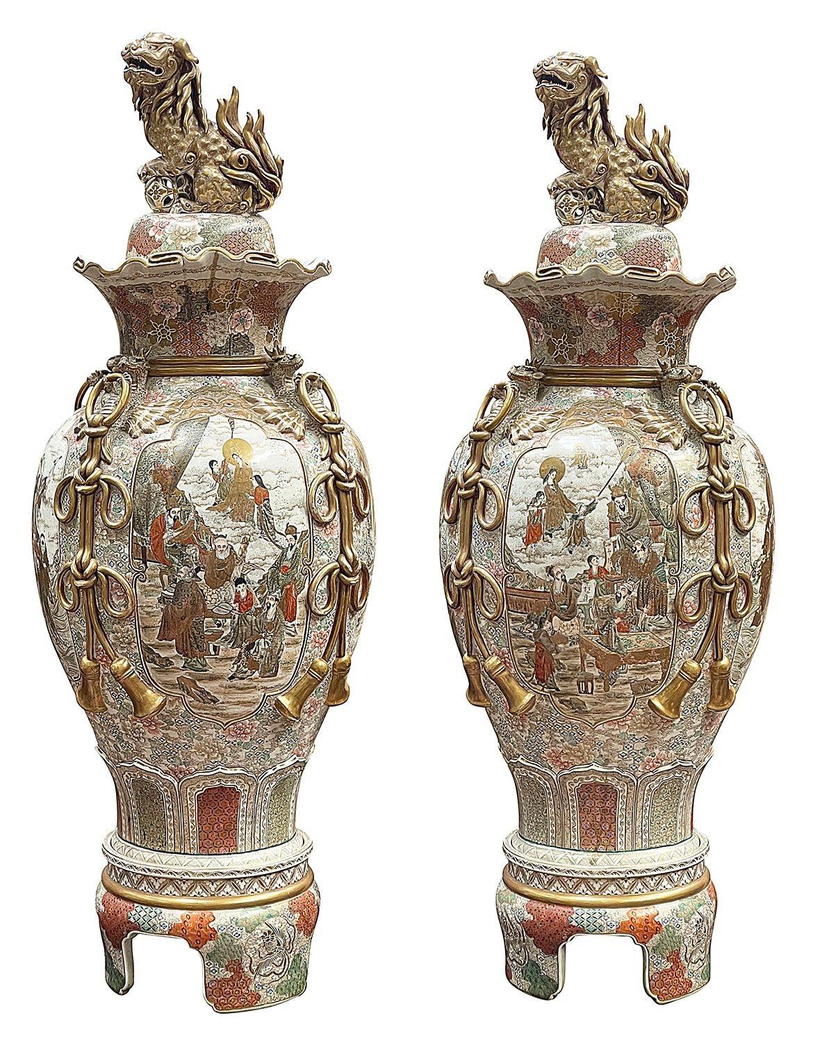A spectacular pair of late 19th Century Japanese Meiji period  (1868-1912) Satsuma lidded vases. Each with wonderful Foo Dog finials to the lids, classical orange and gilded motif decoration with inset hand painted panels depicting, families,