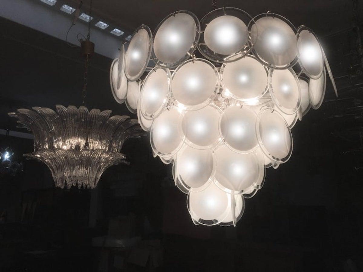 Charming pair of chandeliers by Vistosi made of 50 Murano discs white put on five floors. Six available items with matching wall sconces.