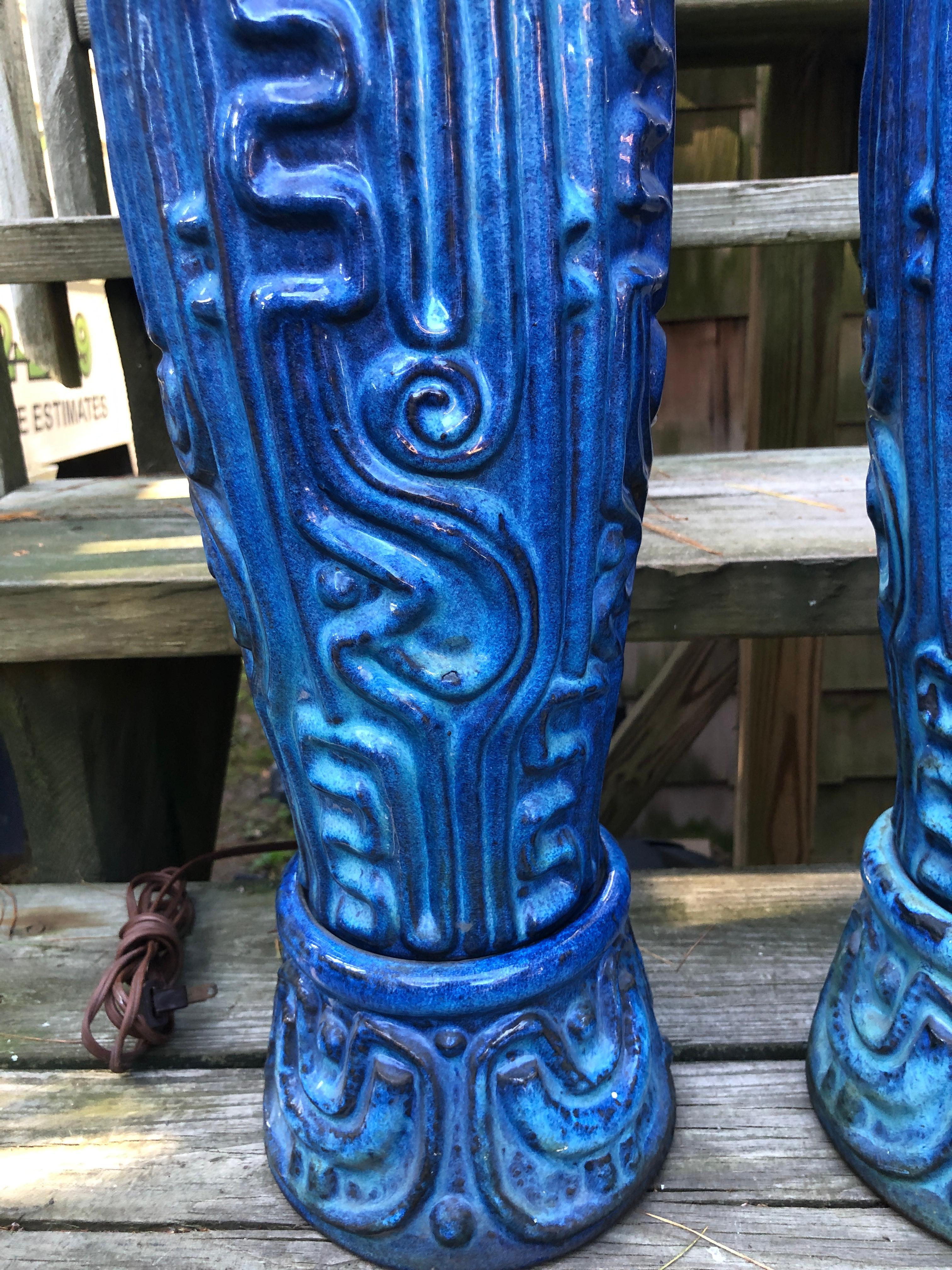Spectacular pair of tall Bitossi style textured blue glazed lamps.  These lamp  are impressive not only in size but also how well they are crafted.  They are highly sculpted Aztec in style with a wonderful cobalt blue glaze over a lighter blue body.