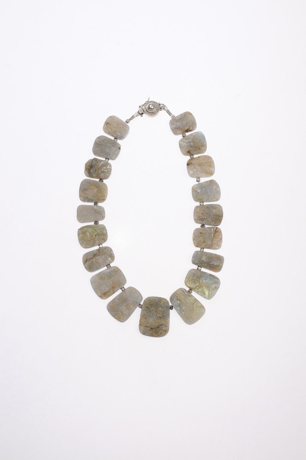 A spectacular necklace of raw labradorite oversized beads strung together in descending size from the center stone with a strong sterling silver clasp. These raw and oversized beads have a shape in between a rectangle and an oval - or a rectangle
