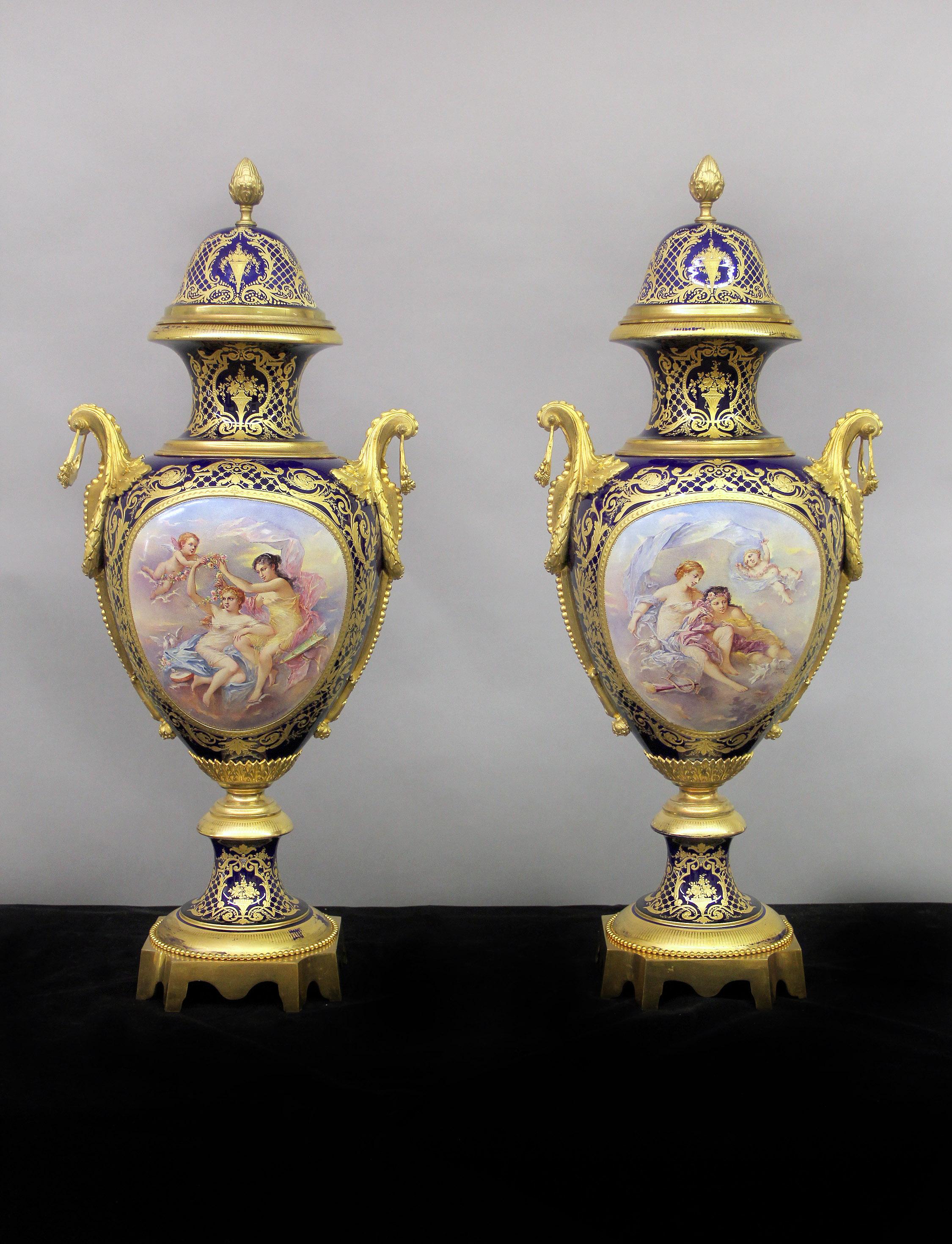 A spectacular set of late 19th century gilt bronze mounted Sèvres style vases and pedestals.

The vases of baluster form, the domed covers surmounted by a pinecone finial, the front with painted scenes of women and cherubs, the reverse with