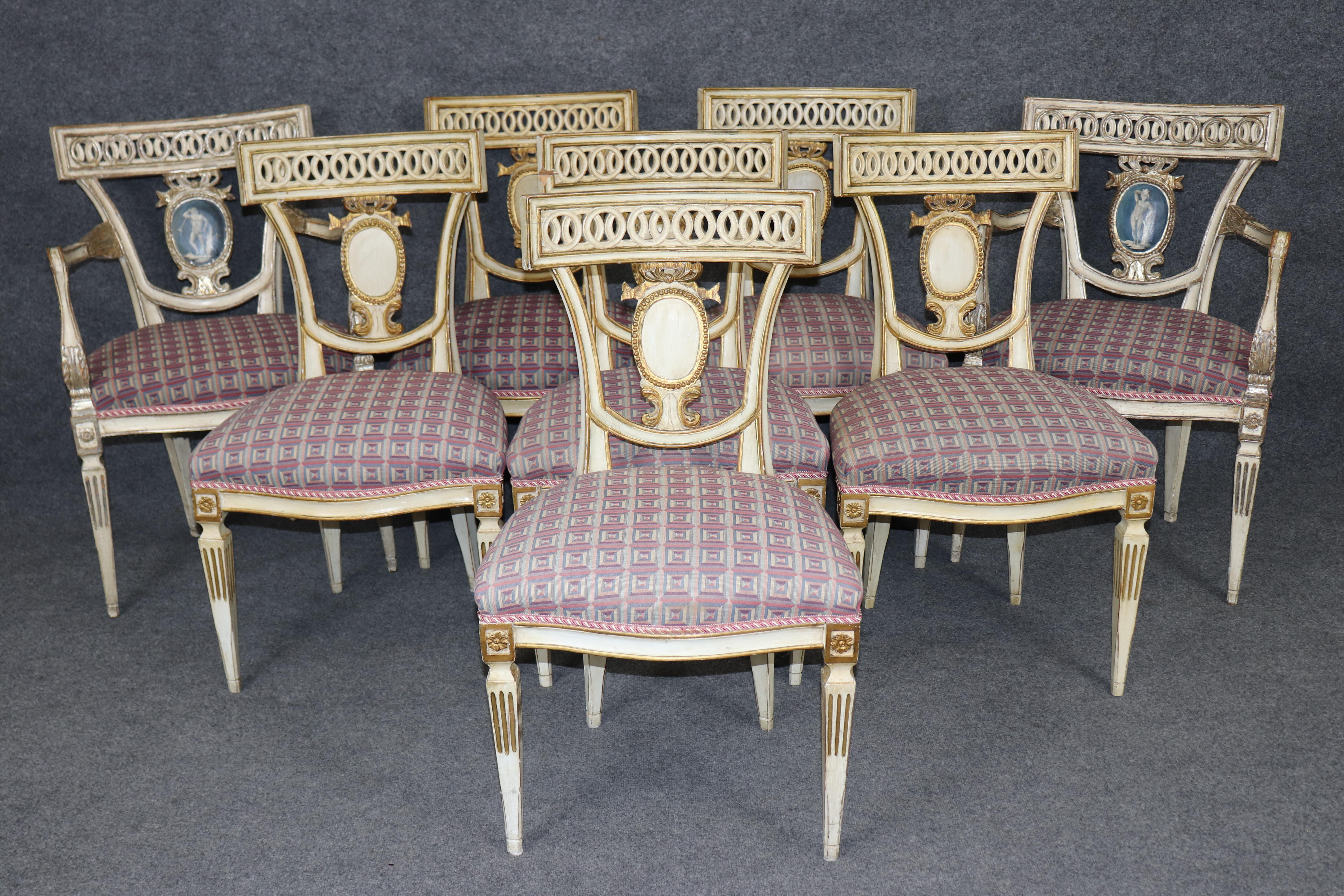 Si tratta di un set davvero unico e speciale di sedie da pranzo neoclassiche italiane di alta qualità. Le sedie sono decorate a vernice con uno sfondo dipinto di crema e accenti in foglia d'oro antico e figure in stile cammeo bianche e blu
