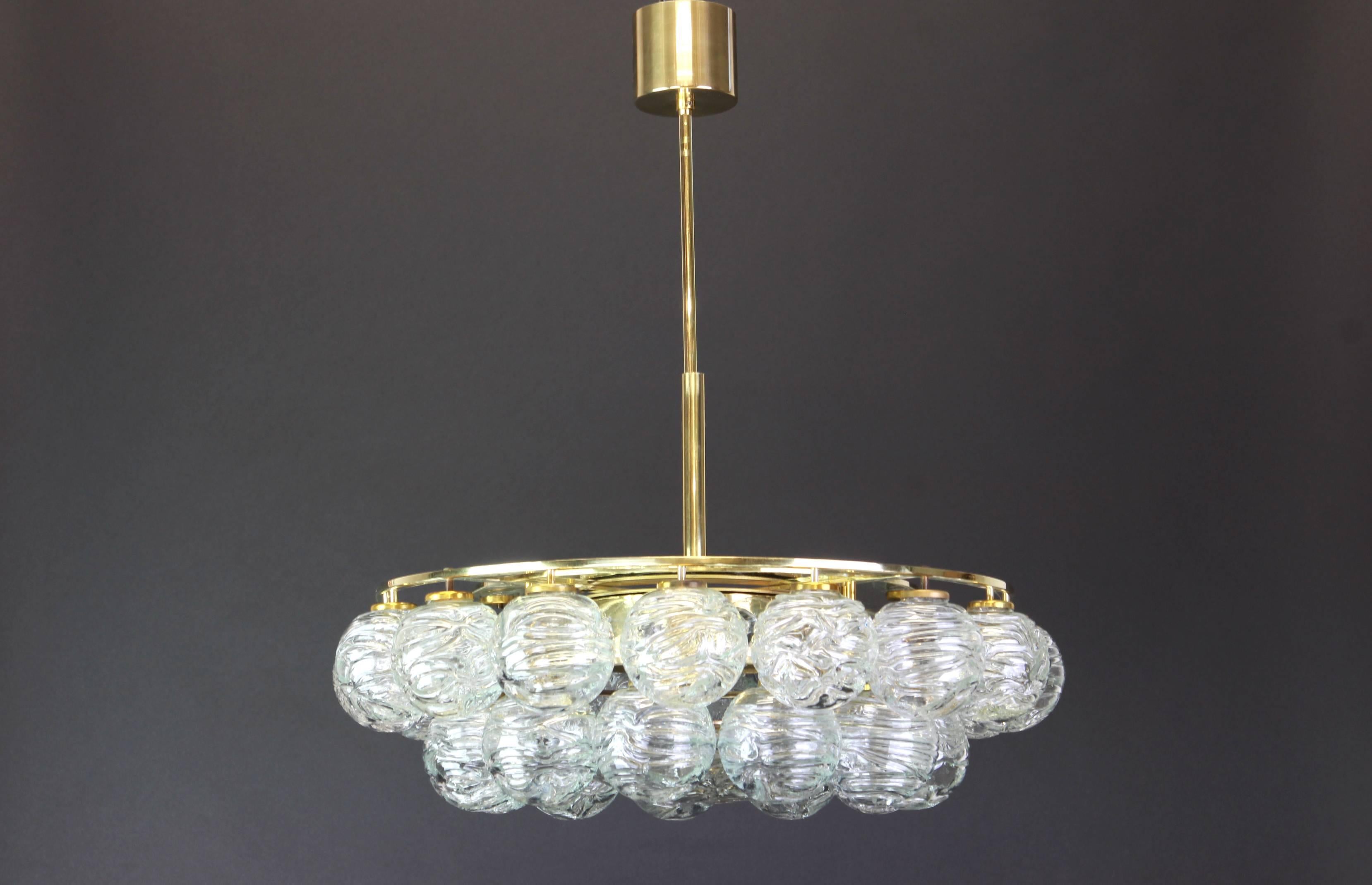 A stunning midcentury chandelier made by Doria Leuchtern, manufactured in Germany, circa 1970-1979.
The chandelier is composed of 31 Murano glass swirl textured ice glass elements (snowballs) attached to a brass frame.
All Murano glass balls are