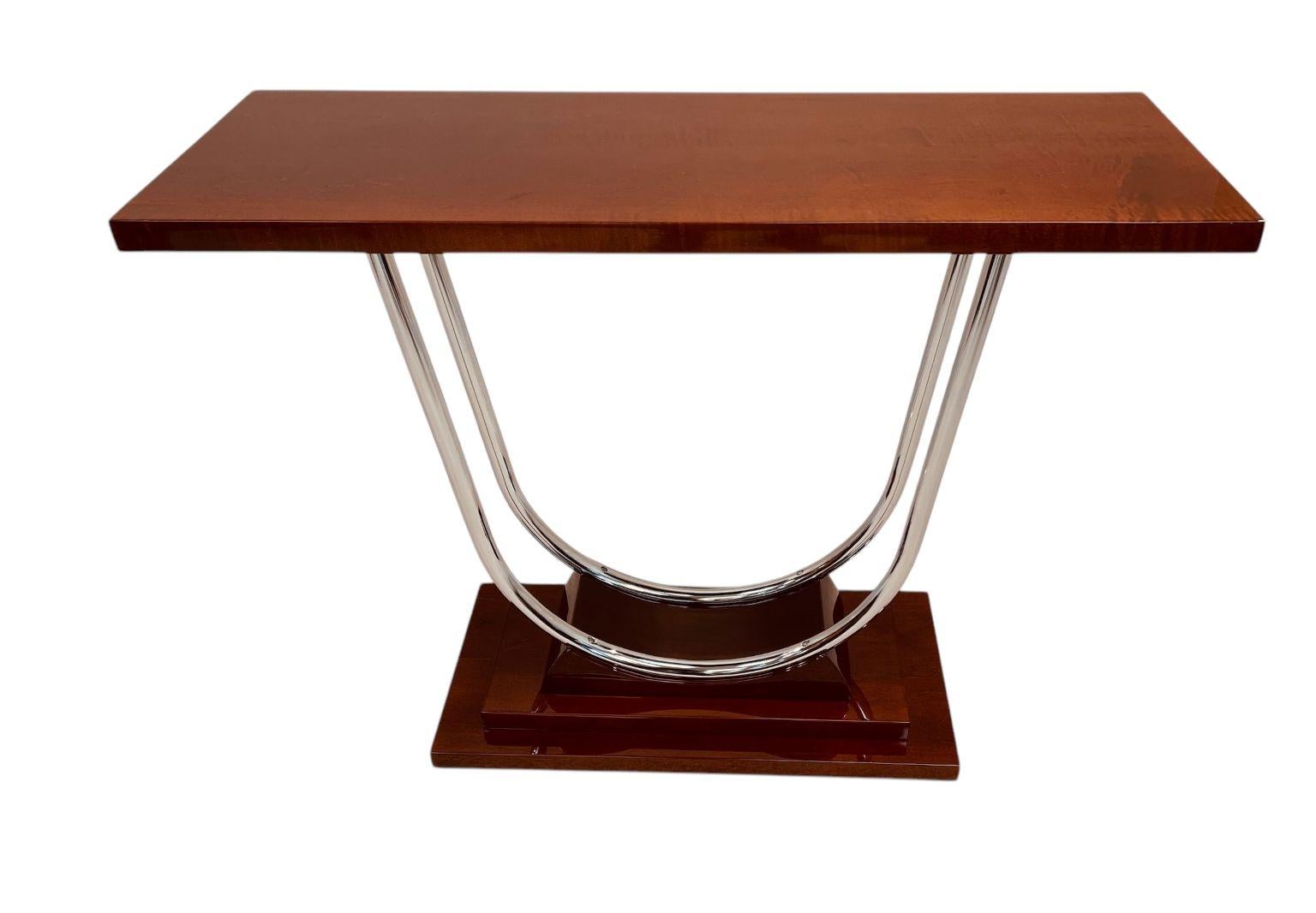 An exquisite Art Deco streamline chrome console table. Beautifully crafted and restored solid maple-stained mahogany. A simple streamline design, stout top supported by two polished chrome supports all sitting on a skyscraper base. An excellent
