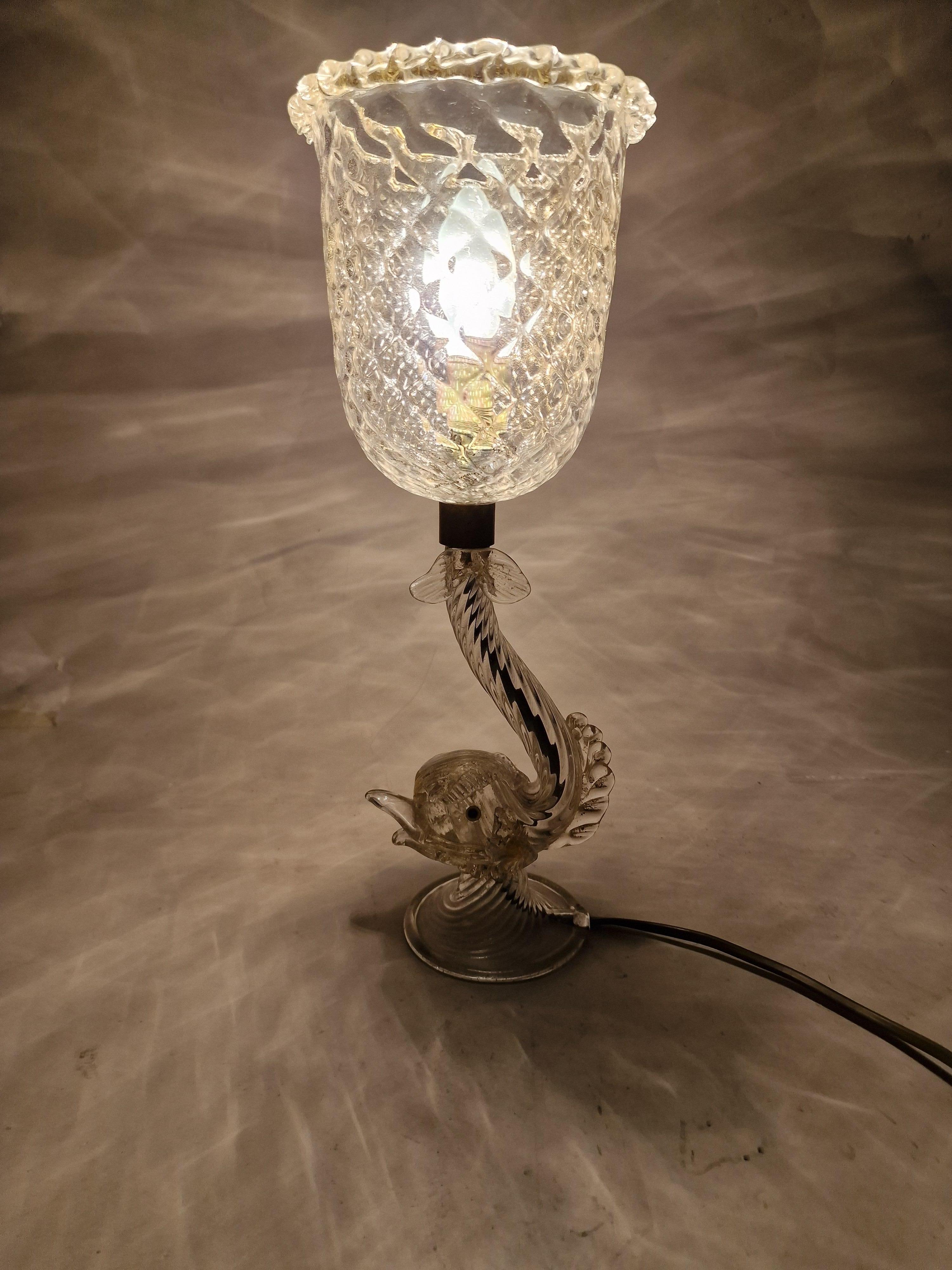 This spectacular table lamp was made at the world-famous glass factory  island of Murano, Venice in Italy. This object is made of masterfully hand-blown glass, made using an old process in the 1960s.

The colorless glass was covered over and over