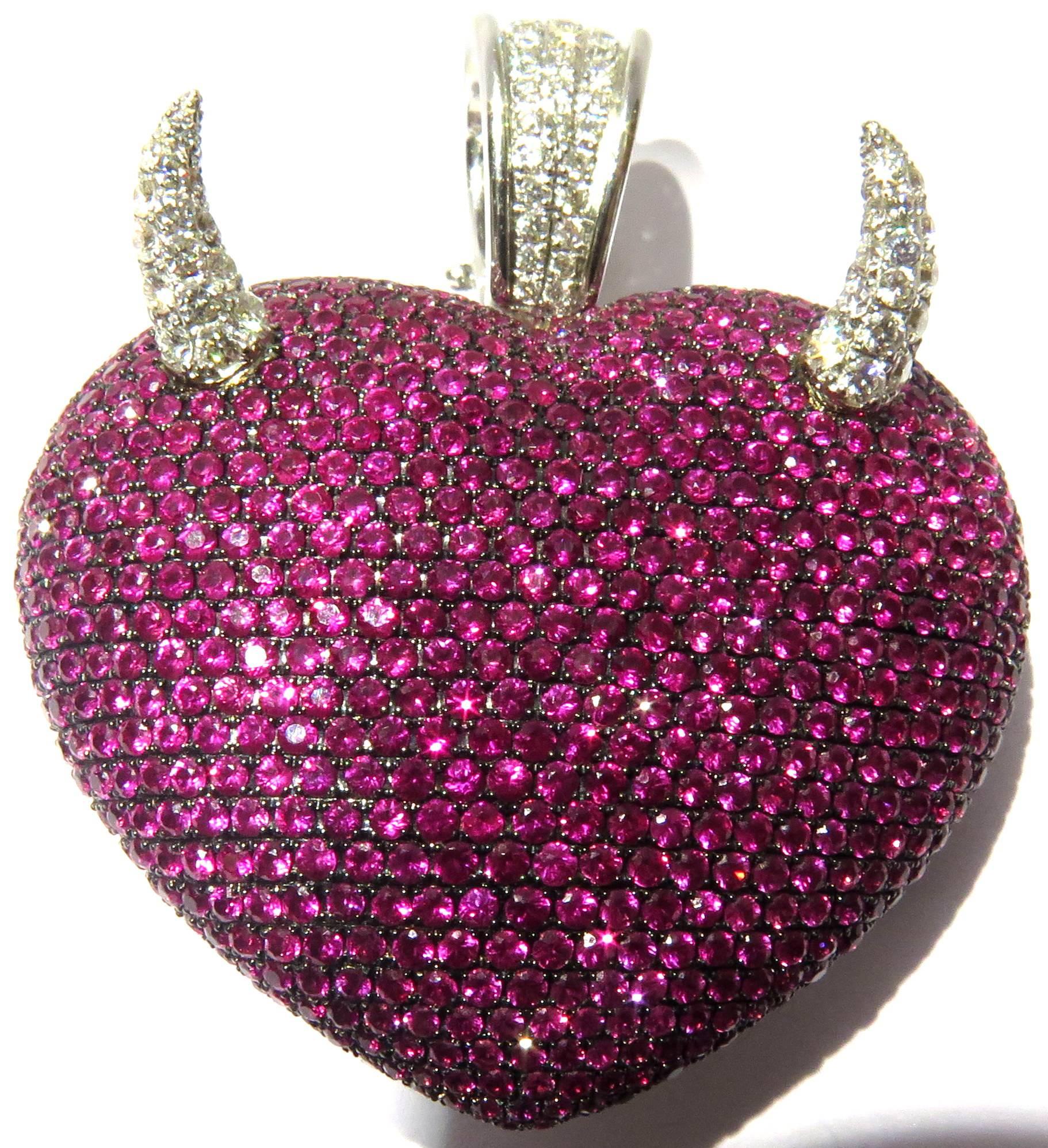 This 18k white gold superbly whimsical extra large size Theo Fennell heart pendant says what others only think.....With it's protruding diamond horns coming from it's multi prong set rubies puffed heart and the tail in the back of the heart, well,