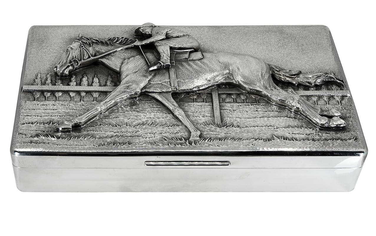 One of a kind sterling silver hinged box.  Made and signed by TIFFANY & CO.  The entire top is hand tooled and decorated.
Depicting a racetrack, with a three-dimensional central image of a horse and rider.  Solid extra-heavy gauge sterling silver. 