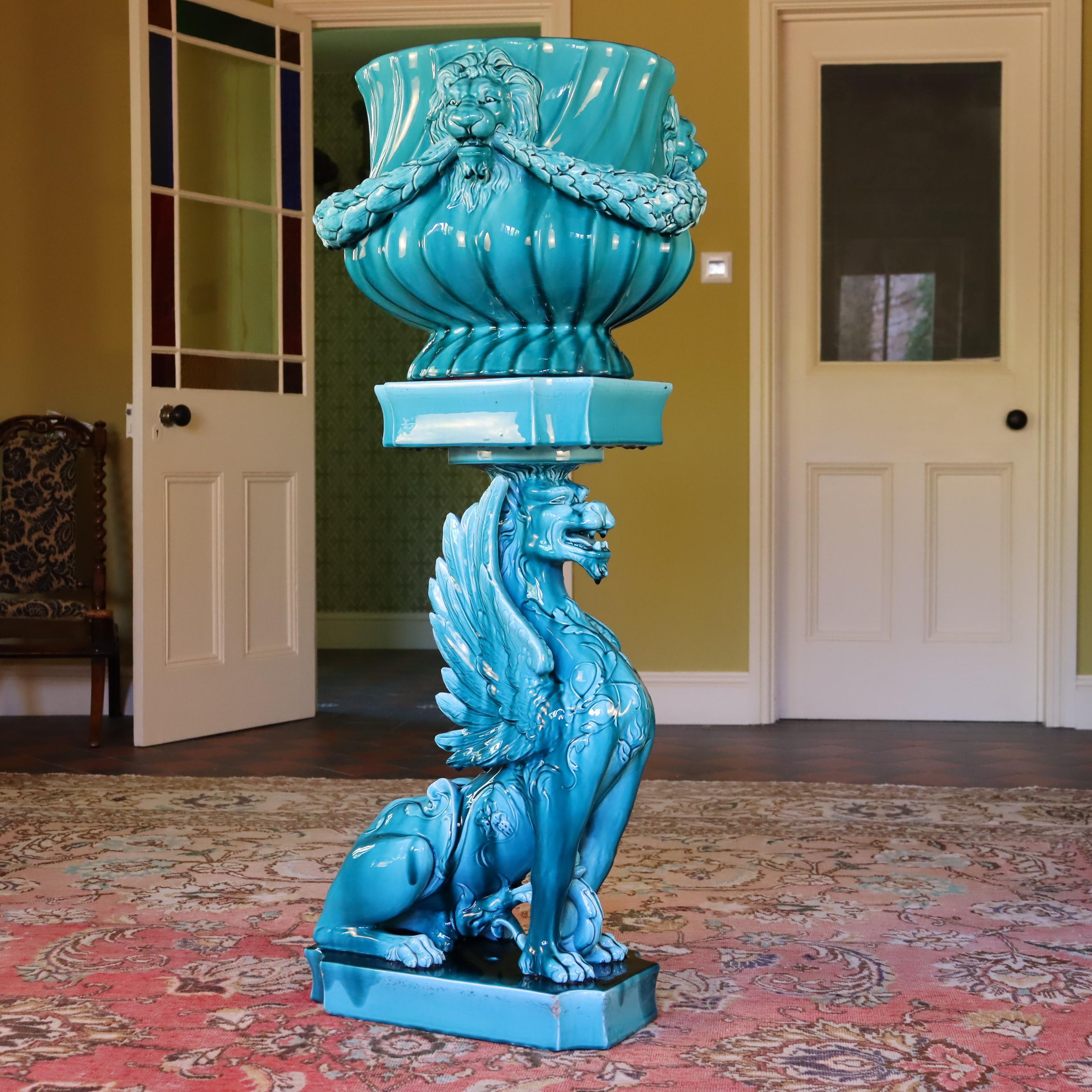 Jardinière et support de griffon en émail lustré de Clément Massier, fournisseur officiel de la Couronne britannique,

La jardinière de forme balustre moulée en spirale, modelée avec trois masques de lions aux mâchoires ouvertes, réunis par des