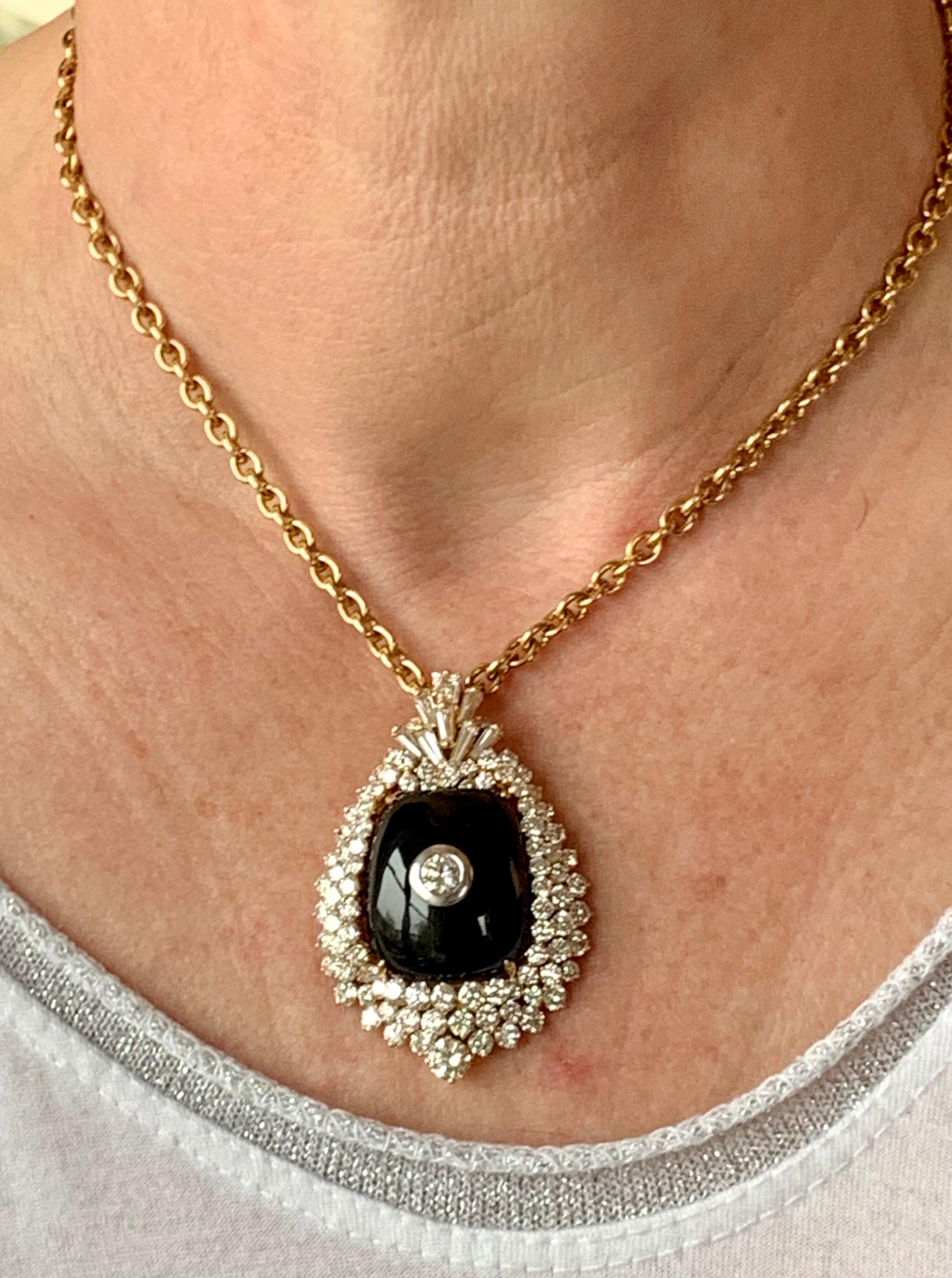 A real eye catcher this Onyx and Diamond Vintage pendant in 18 K white and yellow Gold. The pendant is set with 2 larger brilliant cut Diamonds weighing approximately 0.90 ct, H color, vs clarity, 5 baguette Diamonds weighing ca. 1 ct, and 83