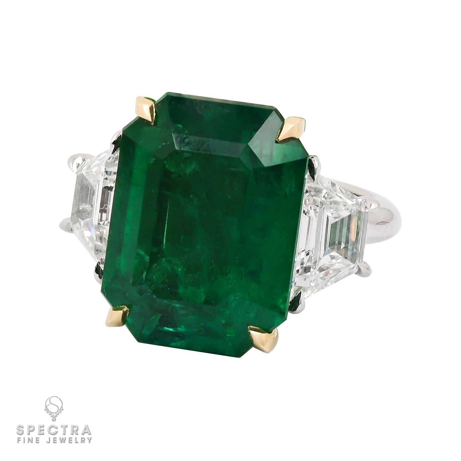 This Contemporary Emerald Diamond Engagement/Cocktail Ring showcases the allure of an emerald-cut green emerald, renowned for its clean lines and vibrant color. The emerald's elongated shape and flattened table facet, reflecting its hexagonal