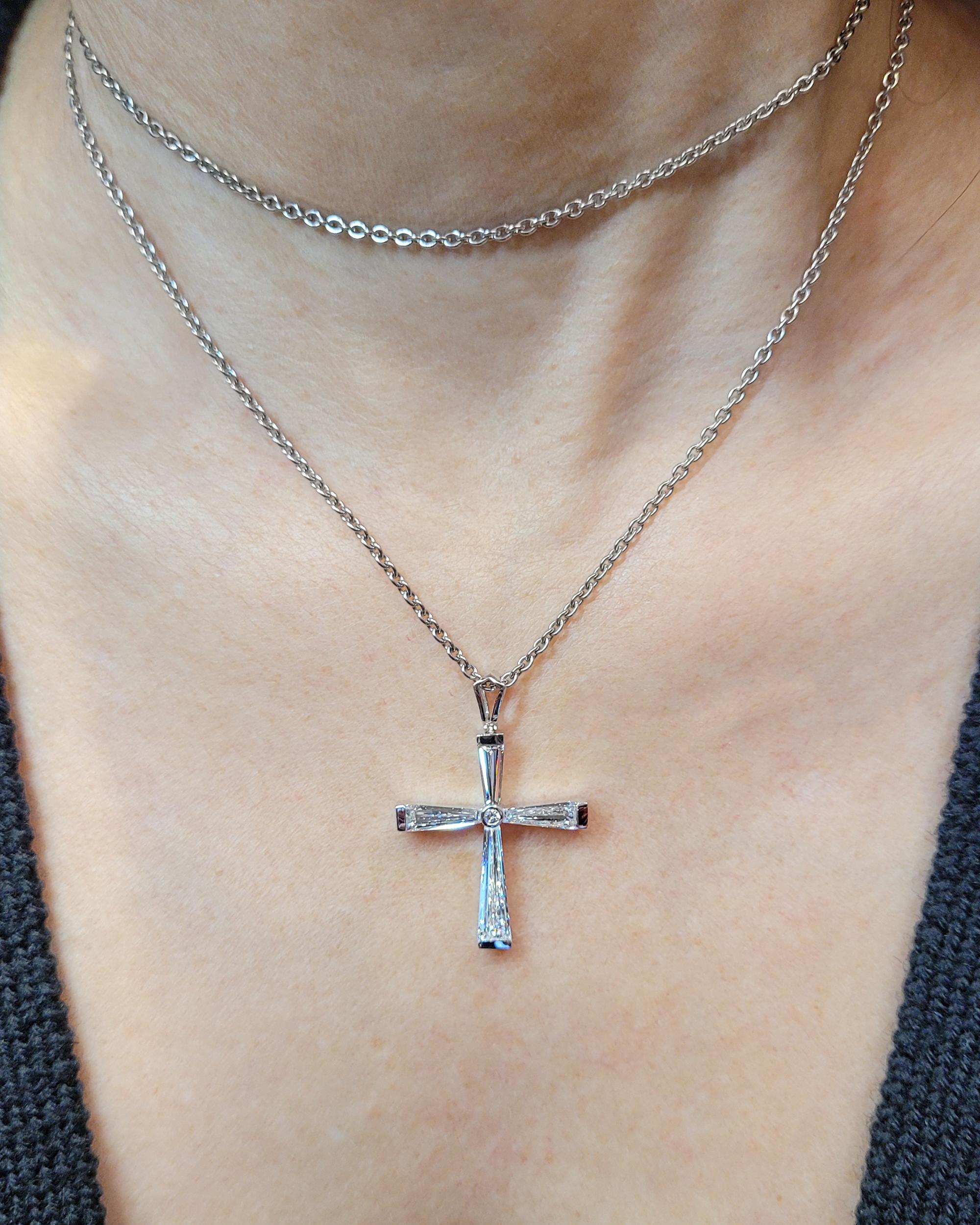 This contemporary cross-diamond pendant from Spectra Fine Jewelry is truly captivating, showcasing four tapered baguette diamonds with a combined weight of 2.50 carats. These diamonds exhibit exceptional quality, boasting a VS1 clarity and E-F