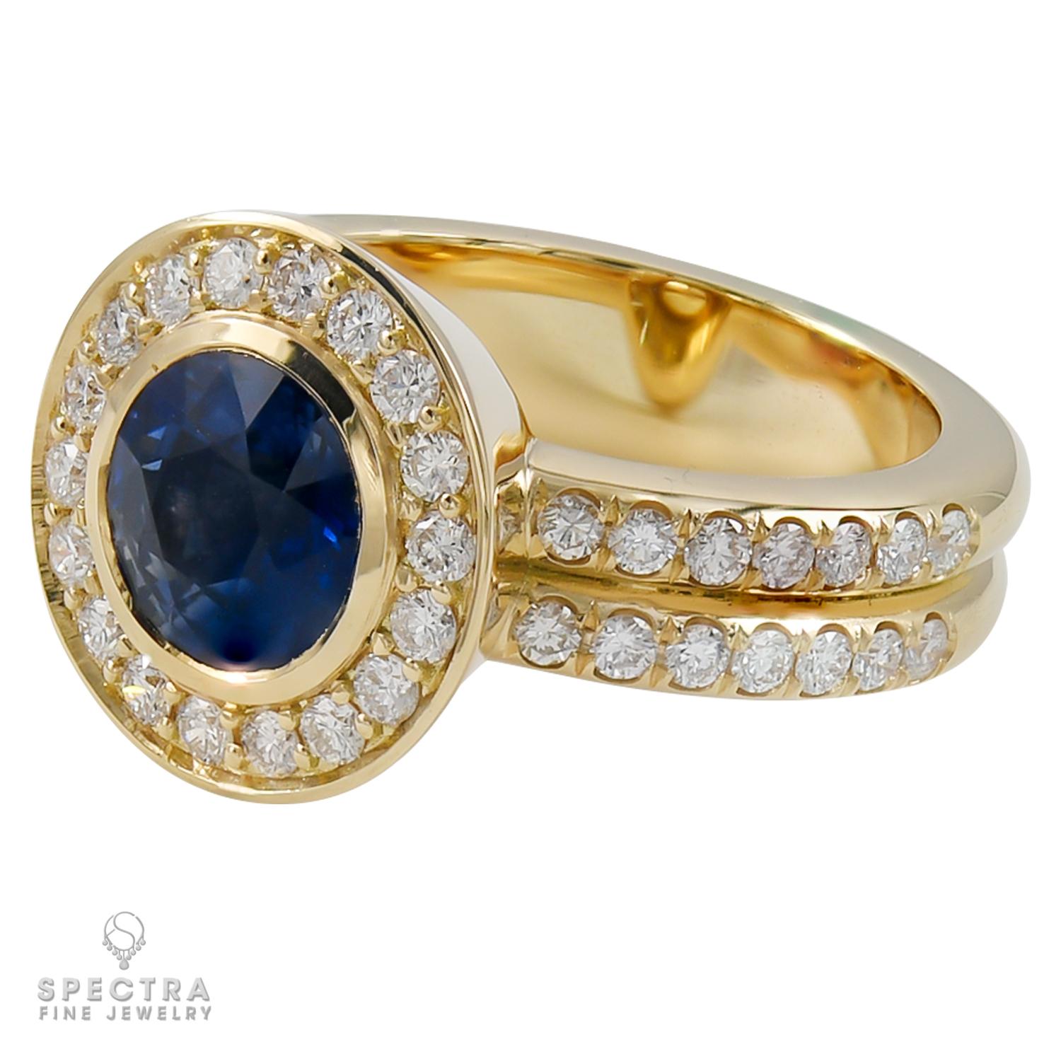 A beautiful ring comprising of a round blue sapphire set in a halo of pave diamonds. 
A double band with pave diamonds set half way. 
Weight of the sapphire is approximately 2 carats.
Total weight of diamonds is 0.6 carats. 
Metal is 18k yellow