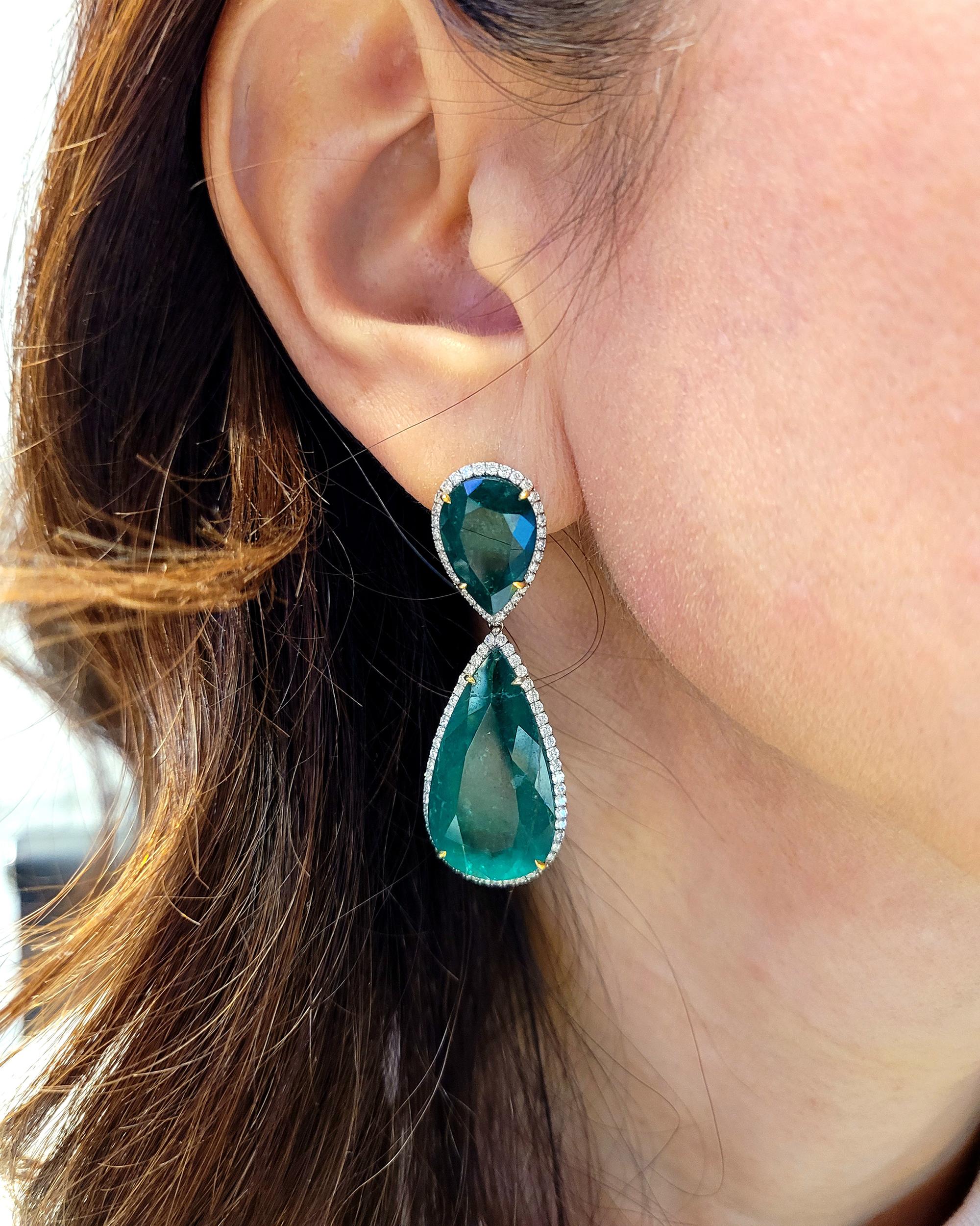 Looking for a stunning pair of drop earrings that will make a statement? Look no further than these exquisite emerald and diamond earrings. Featuring four pear-shaped Colombian emeralds, these earrings are a true masterpiece of jewelry design. The