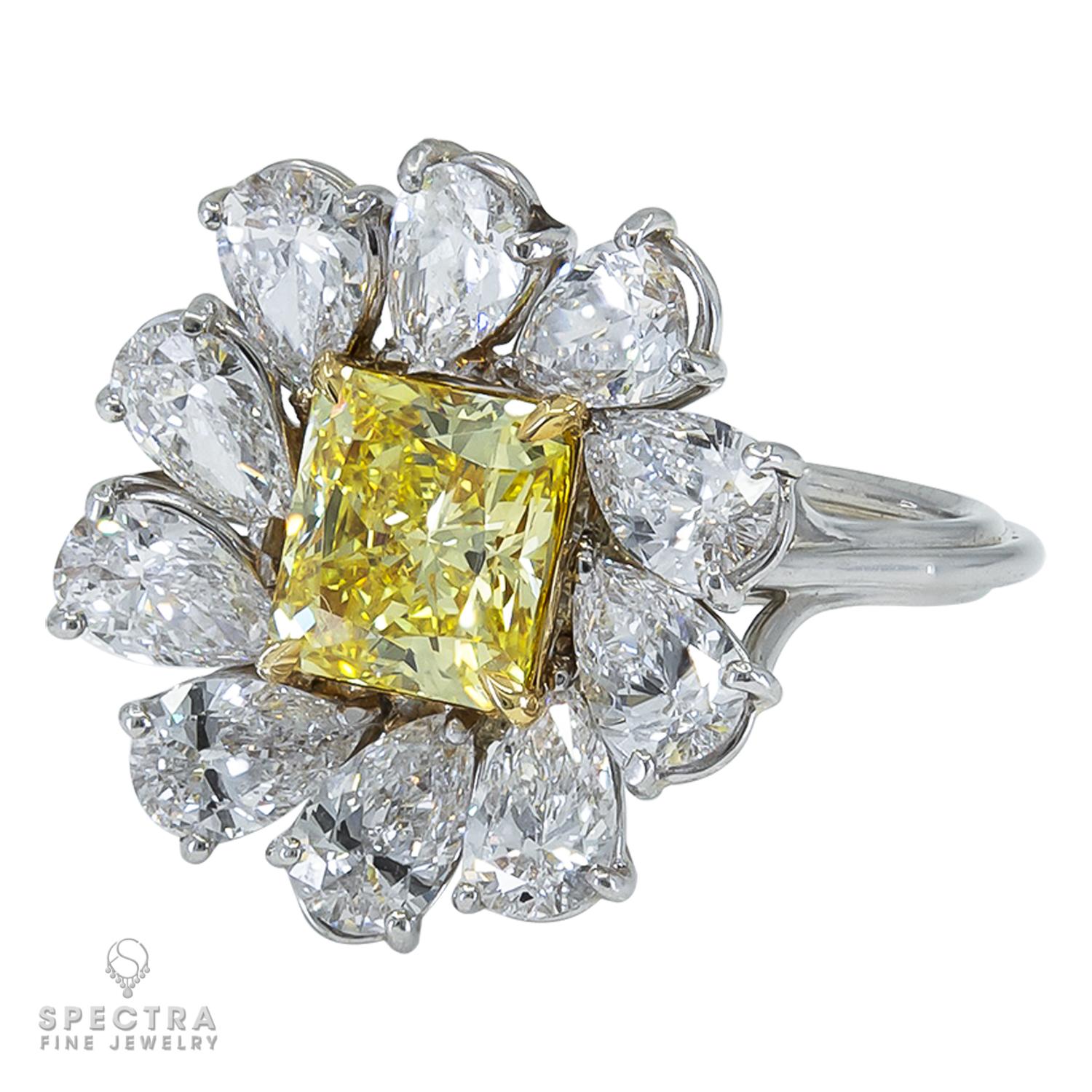 A cocktail ring showcasing a fancy vivid yellow radiant cut diamond weighing a total of 1.47 carats, VVS1 clarity.
The diamond is certified by GIA. 
The center stone is accented with 10 pear shape diamonds, G-H color, VS clarity.
Metal is platinum