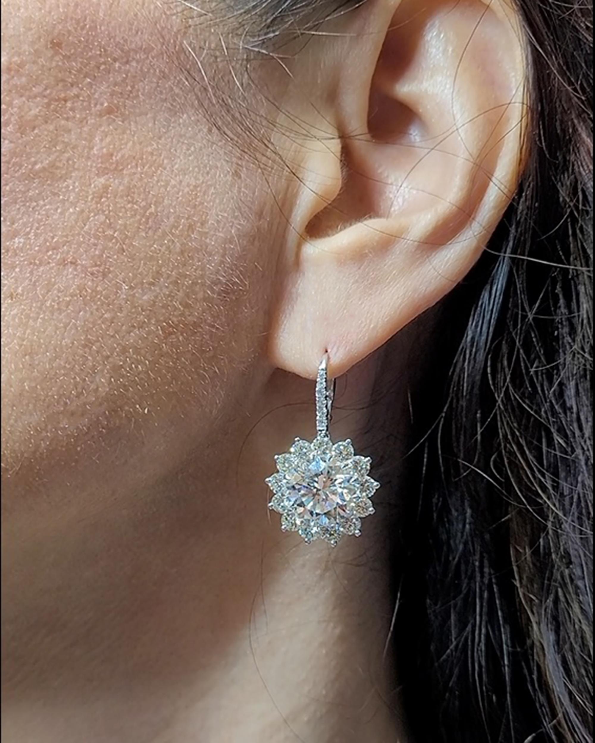 A pair of important earrings designed as a flower and mounted in platinum.
Comprising of two round diamonds in the center, certified by GIA stating that they are 5.76 carat J VS2 and 5.88 carat I VVS1.
26 round diamonds around the center stones